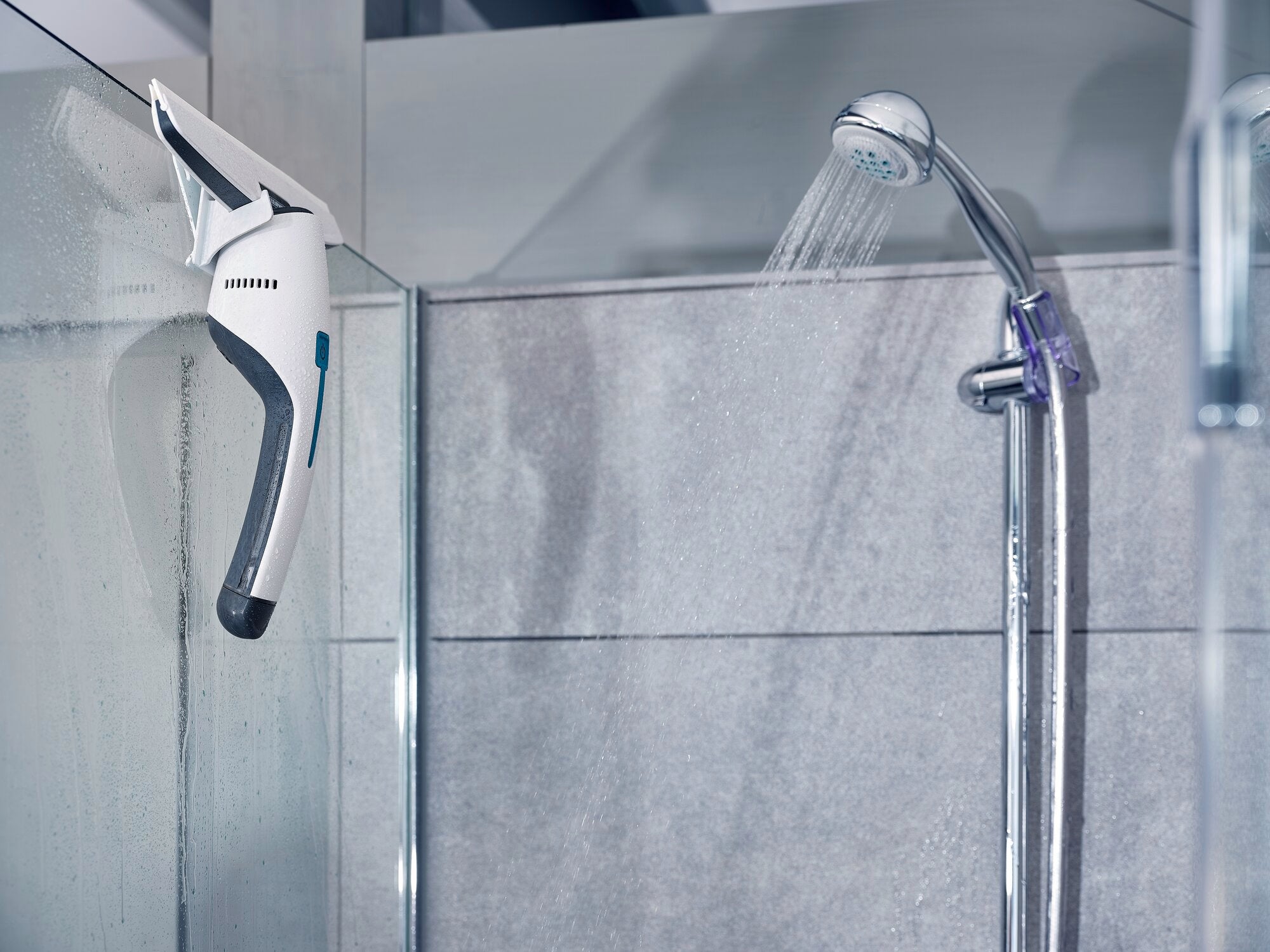 Fenster- und Badsauger Nemo in einer modernen Dusche. Das Gerät ist an einer Glaswand befestigt und zeigt seine praktische Anwendung im Badezimmer.