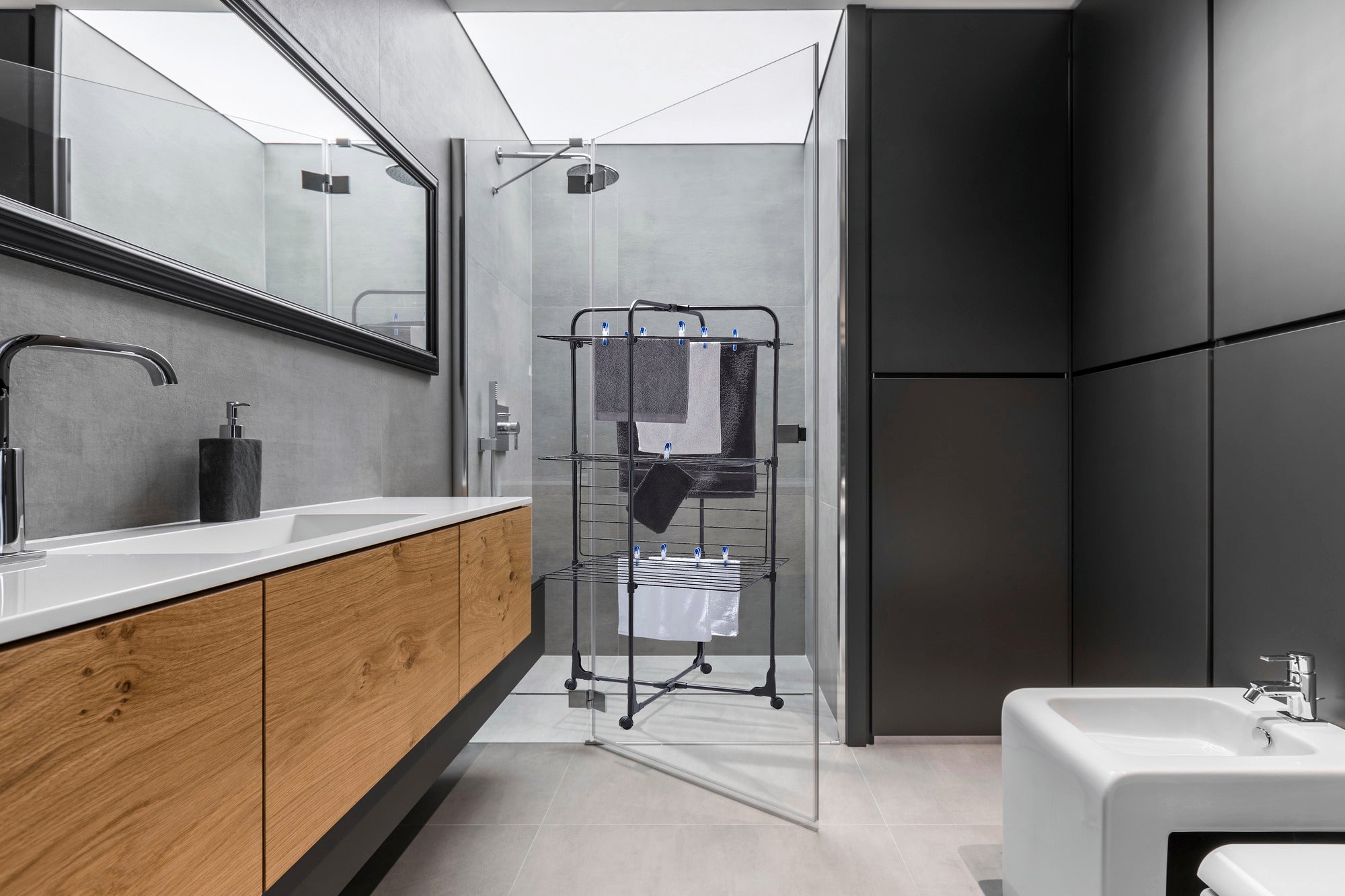 Classic Tower 270 tower dryer in a modern bathroom with glass shower and wooden washbasin. The dryer is compact and offers space for several towels.