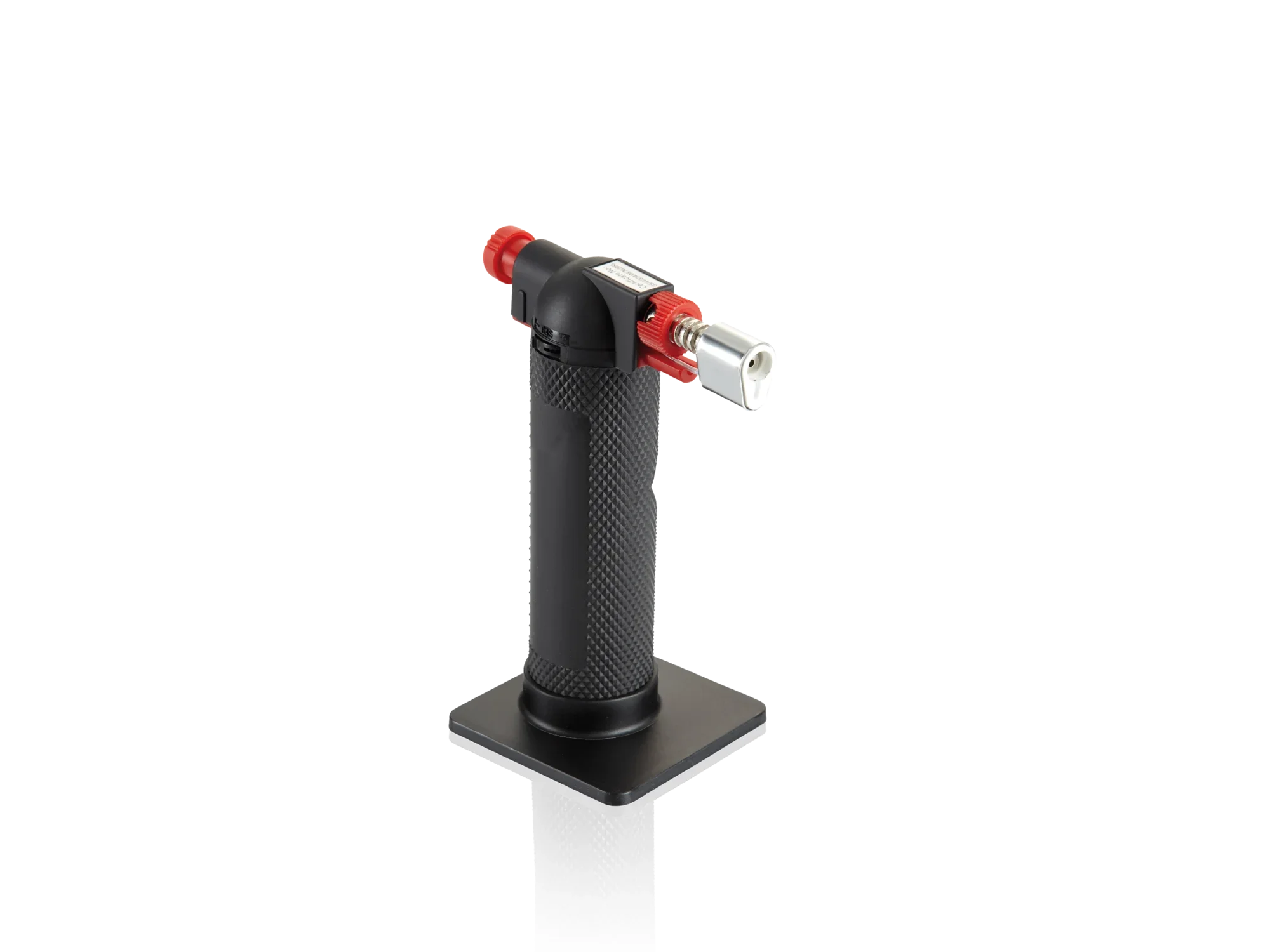 Een zwarte flambeerbrander met rood ontstekingsmechanisme en zilveren mondstuk staat rechtop op een vierkante voet. Ideaal om suiker te karamelliseren of voedsel in vuur en vlam te zetten.