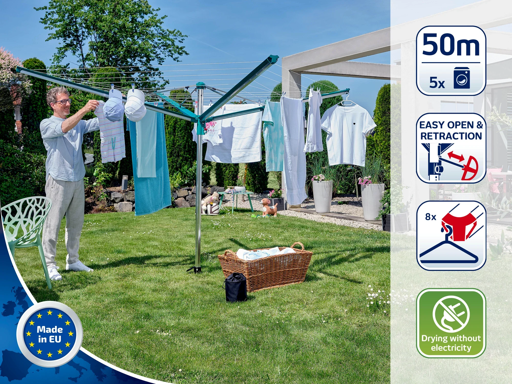 Mężczyzna wiesza pranie na suszarce obrotowej w słonecznym ogrodzie. Suszarka obrotowa ma 50 metrów linki i można ją łatwo otwierać i zamykać. Idealna do ekologicznego suszenia bez użycia prądu.