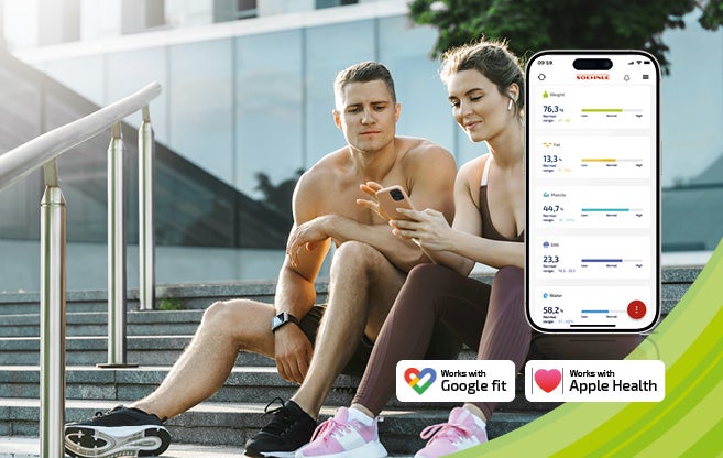 Ein Mann und eine Frau in Sportkleidung sitzen auf Treppenstufen und betrachten ein Smartphone mit Gesundheitsdaten, App-Logos sichtbar.