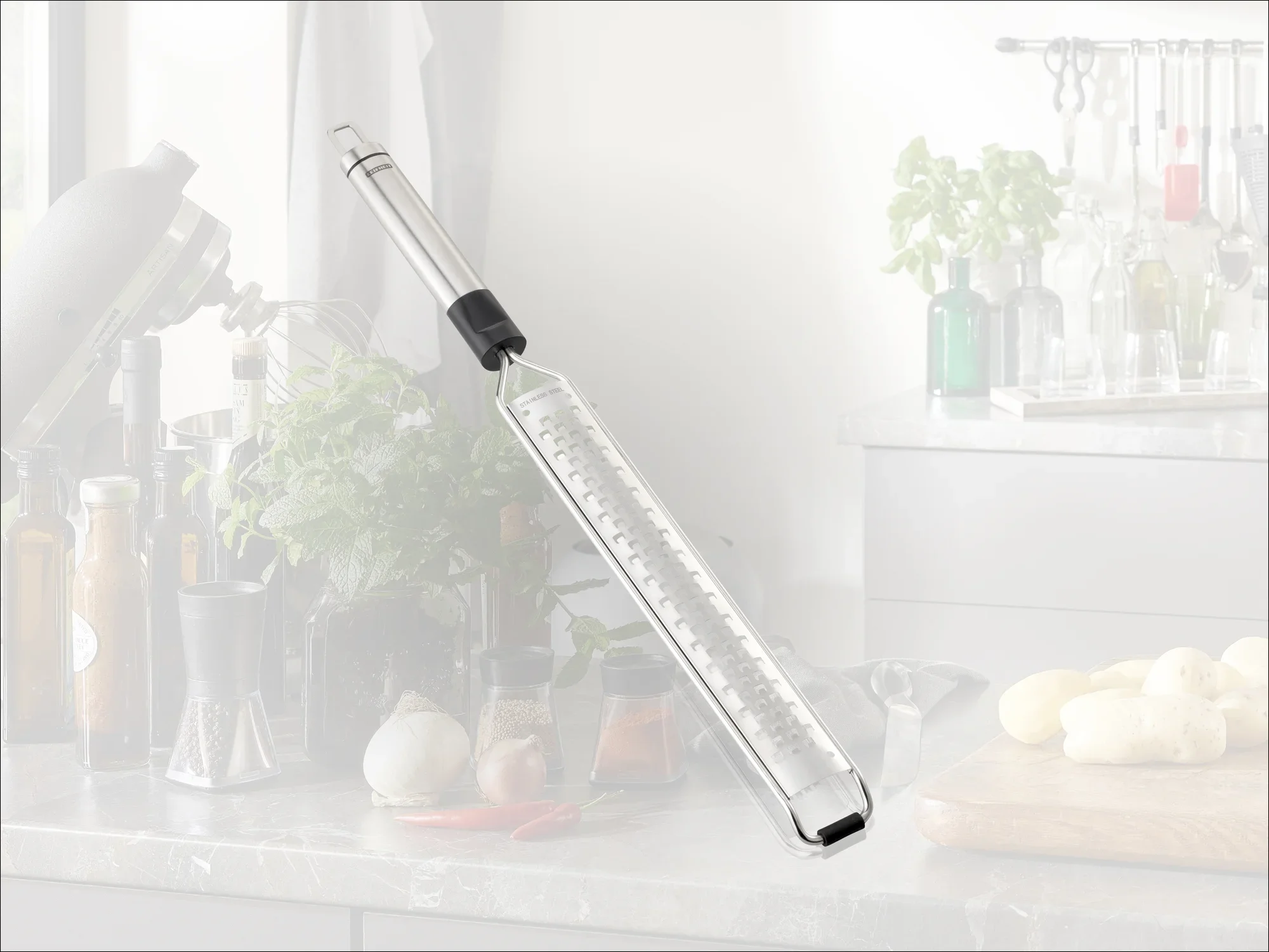 Une râpe de cuisine de haute qualité avec une poignée ergonomique, idéale pour râper finement les ingrédients. En arrière-plan, on aperçoit une cuisine moderne avec des herbes fraîches et des épices.