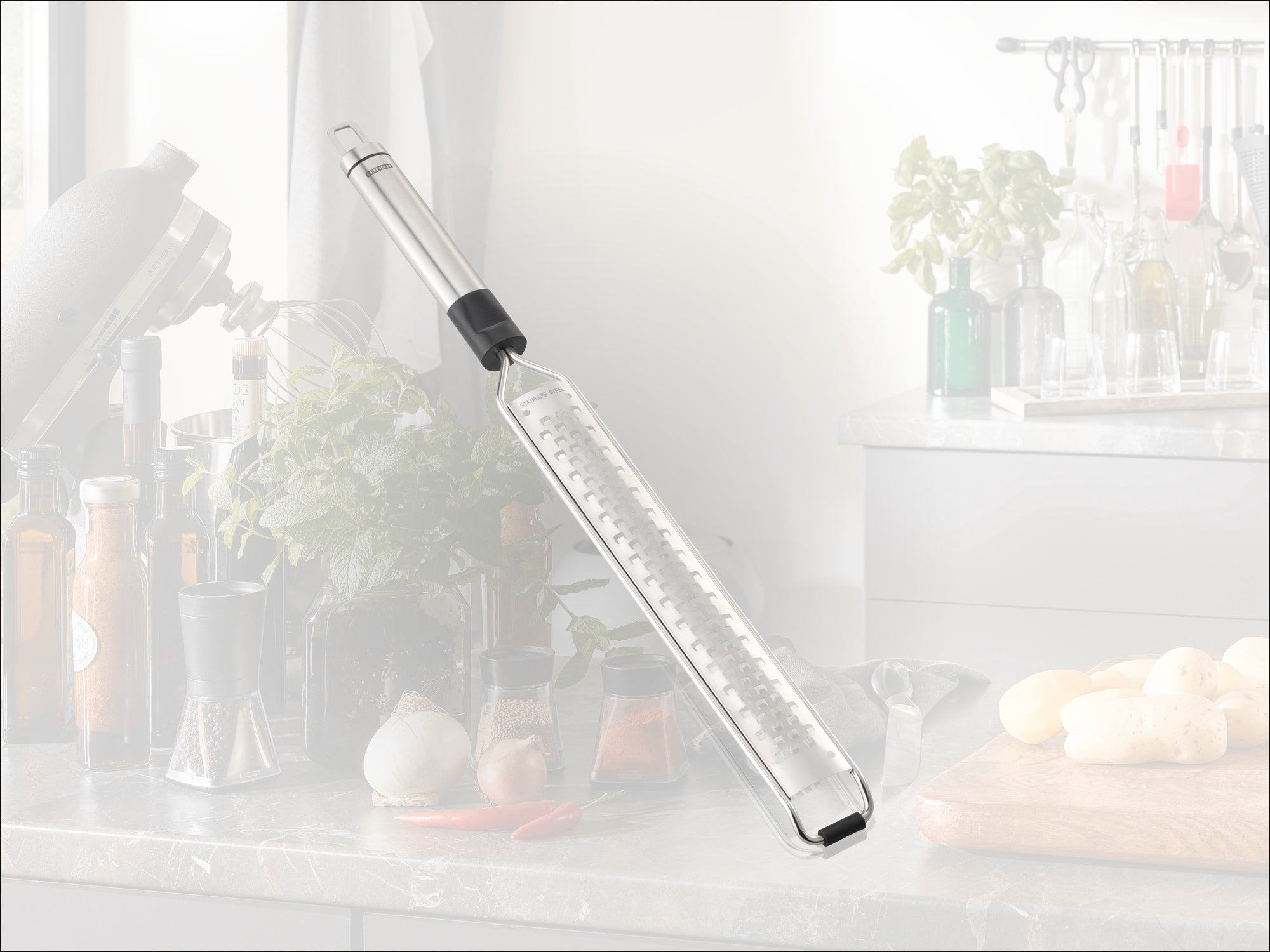 Una grattugia da cucina di alta qualità con impugnatura ergonomica, ideale per grattugiare finemente gli ingredienti. Sullo sfondo si vede una cucina moderna con erbe aromatiche fresche e spezie.