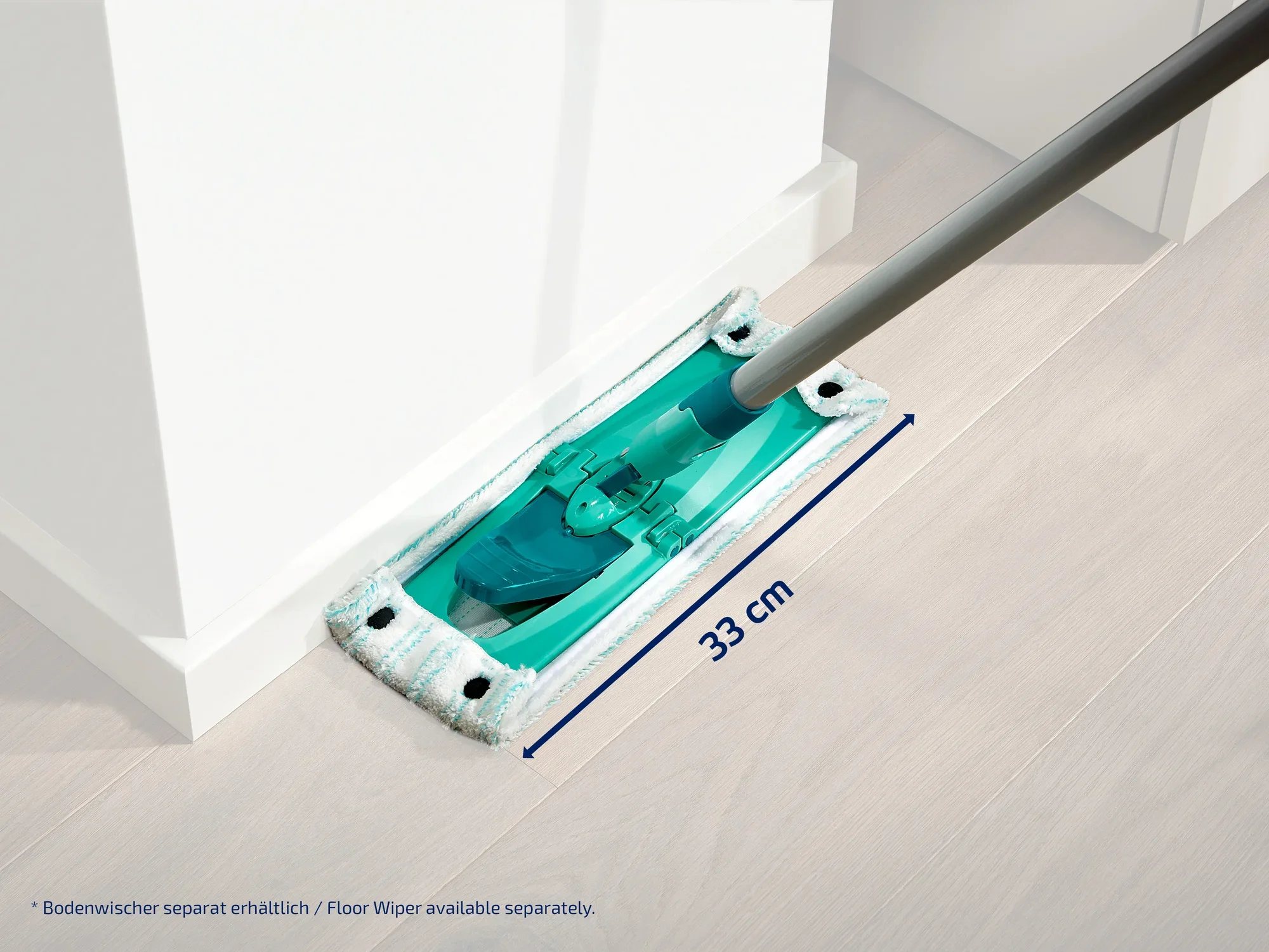 A floor mop with a 33 cm wide mop head is guided along a wall. The mop head is turquoise and has a modern design. Ideal for cleaning corners and edges.