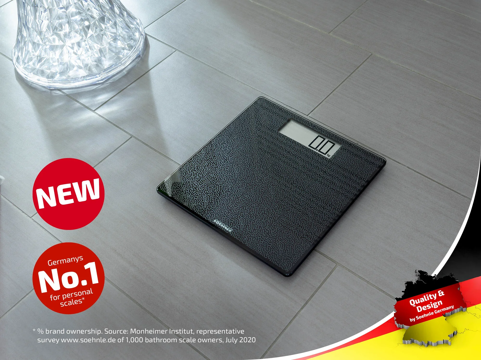 Cyfrowa waga łazienkowa z czarną powierzchnią leży na szarej podłodze wyłożonej kafelkami. W lewym górnym rogu widnieje napis "NEW" i "Germany's No.1 for bathroom scales". W prawym dolnym rogu znajduje się znak jakości.