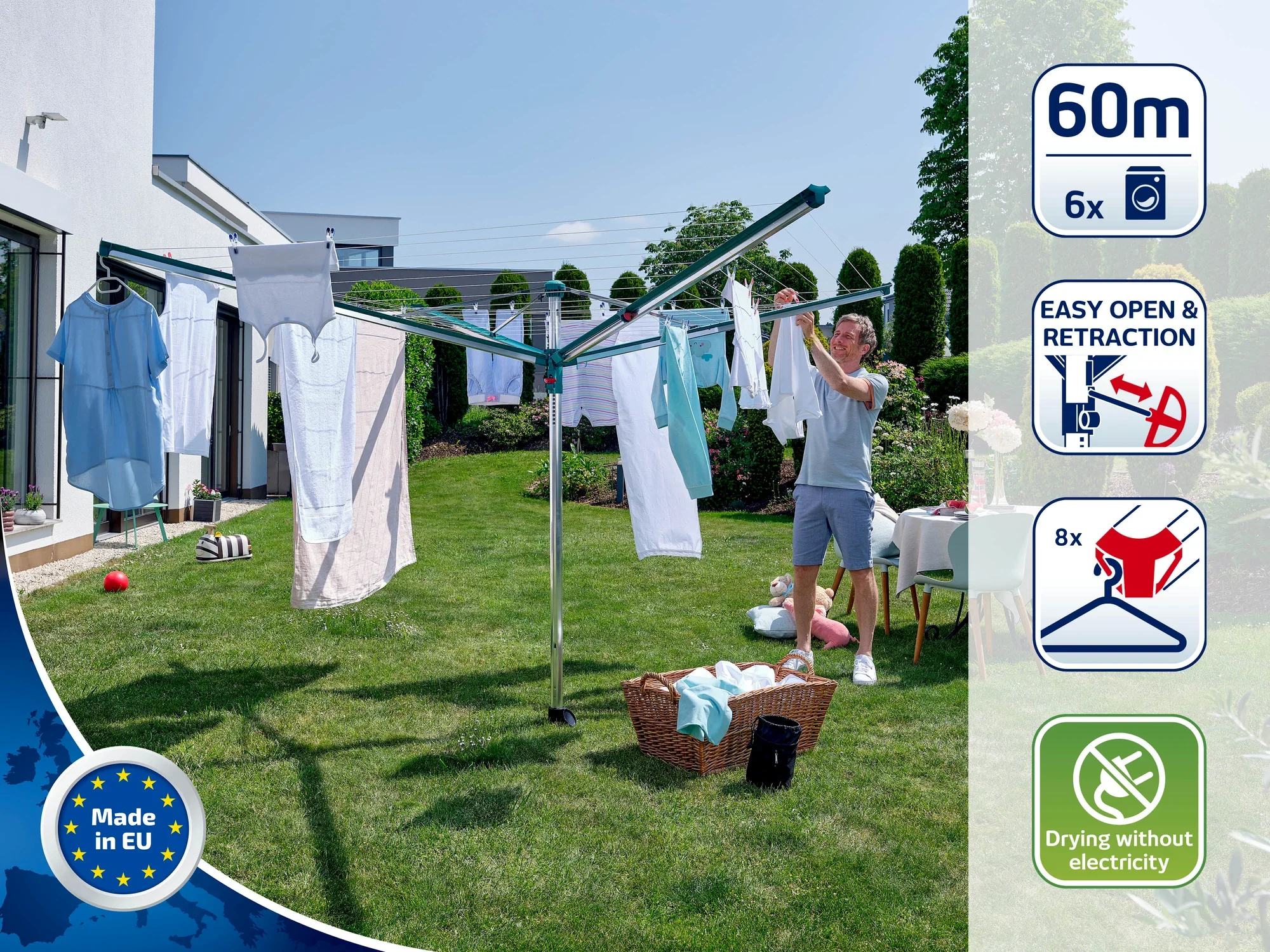 Obrotowa suszarka do ubrań stoi w ogrodzie, załadowana świeżo wypranymi ubraniami. Mężczyzna rozwiesza kolejne ubrania. Suszarka obrotowa może pomieścić do 60 metrów prania i można ją łatwo otwierać i zamykać. Idealna do ekologicznego suszenia bez użycia