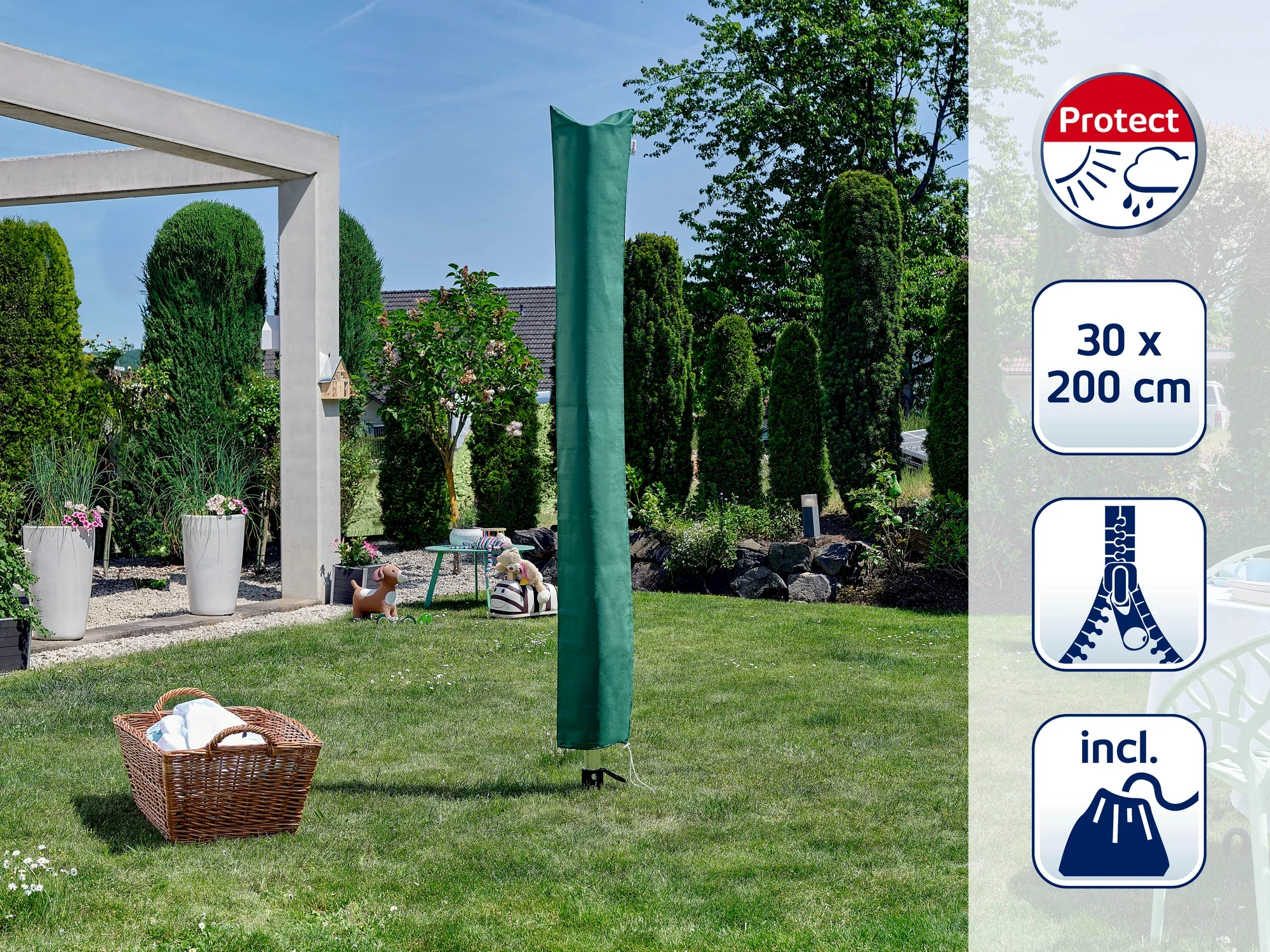 Zielona pokrywa ochronna obrotowej suszarki do ubrań stoi na zadbanym trawniku. W tle widać drzewa i nowoczesną szopę ogrodową. Obok leży kosz z praniem.