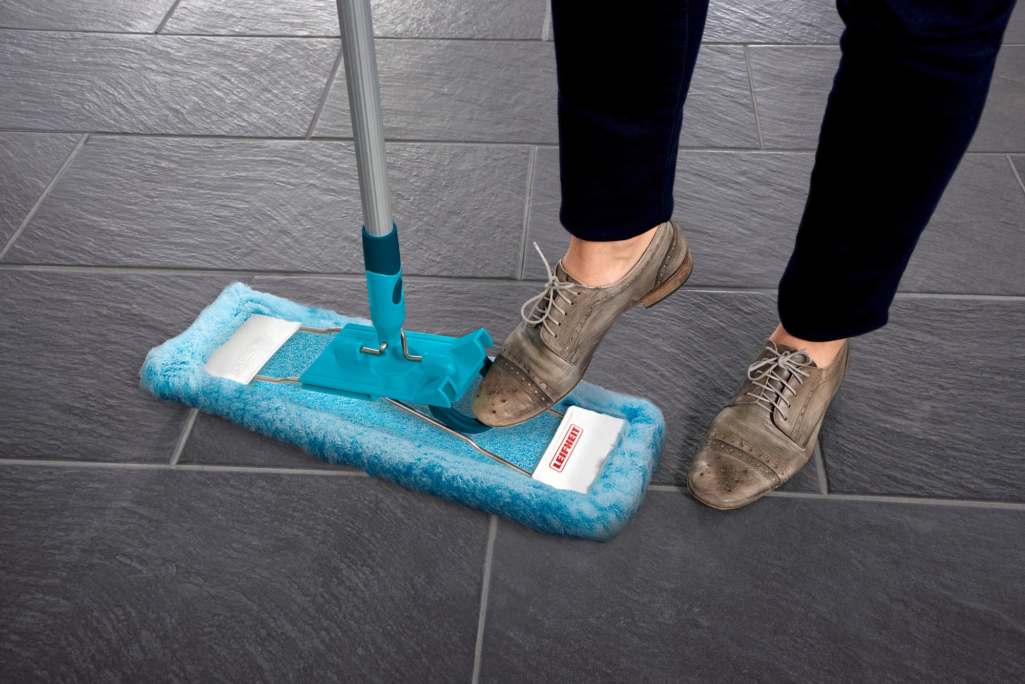 Profi XL mopovertrek in gebruik op een donkere tegelvloer. De hoes is turquoise en wordt gebruikt met een steel. Ideaal voor het grondig schoonmaken van grote oppervlakken.