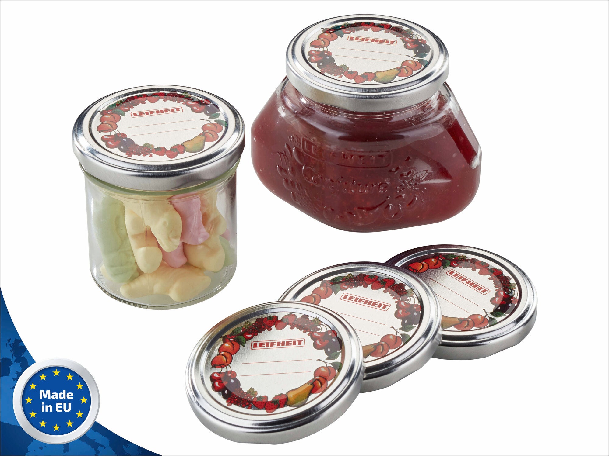 Drei Leifheit Confiture-Gläser mit Ersatzdeckeln, gefüllt mit Süßigkeiten und Marmelade. Die Deckel sind mit einem dekorativen Fruchtmotiv verziert. Hergestellt in der EU.