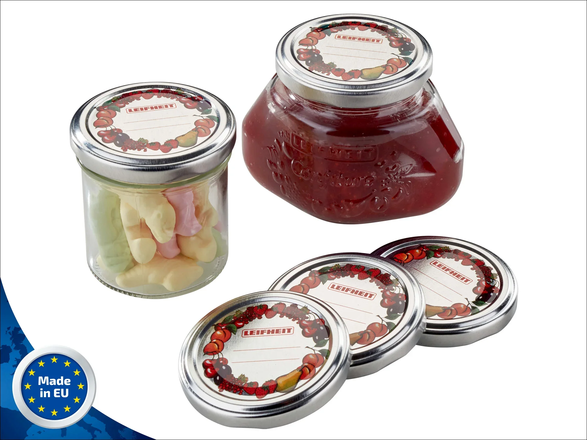 Drei Leifheit Confiture-Gläser mit Ersatzdeckeln, gefüllt mit Süßigkeiten und Marmelade. Die Deckel sind mit einem dekorativen Fruchtmotiv verziert. Hergestellt in der EU.