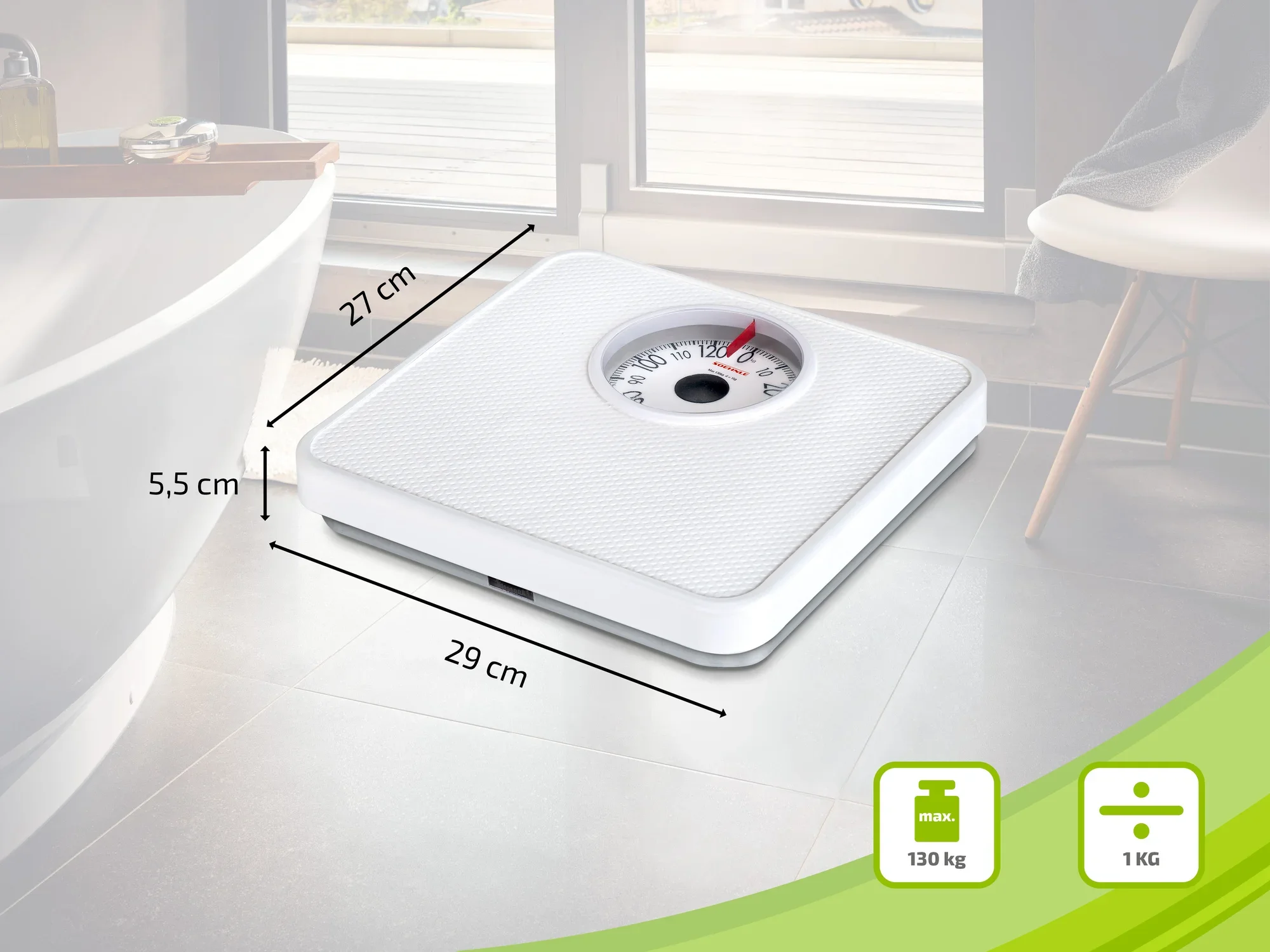 Biała waga łazienkowa z analogowym wyświetlaczem, stojąca na podłodze w łazience. Wymiary to 29 cm x 27 cm x 5,5 cm. Maksymalne obciążenie: 130 kg, dokładność: 1 kg.
