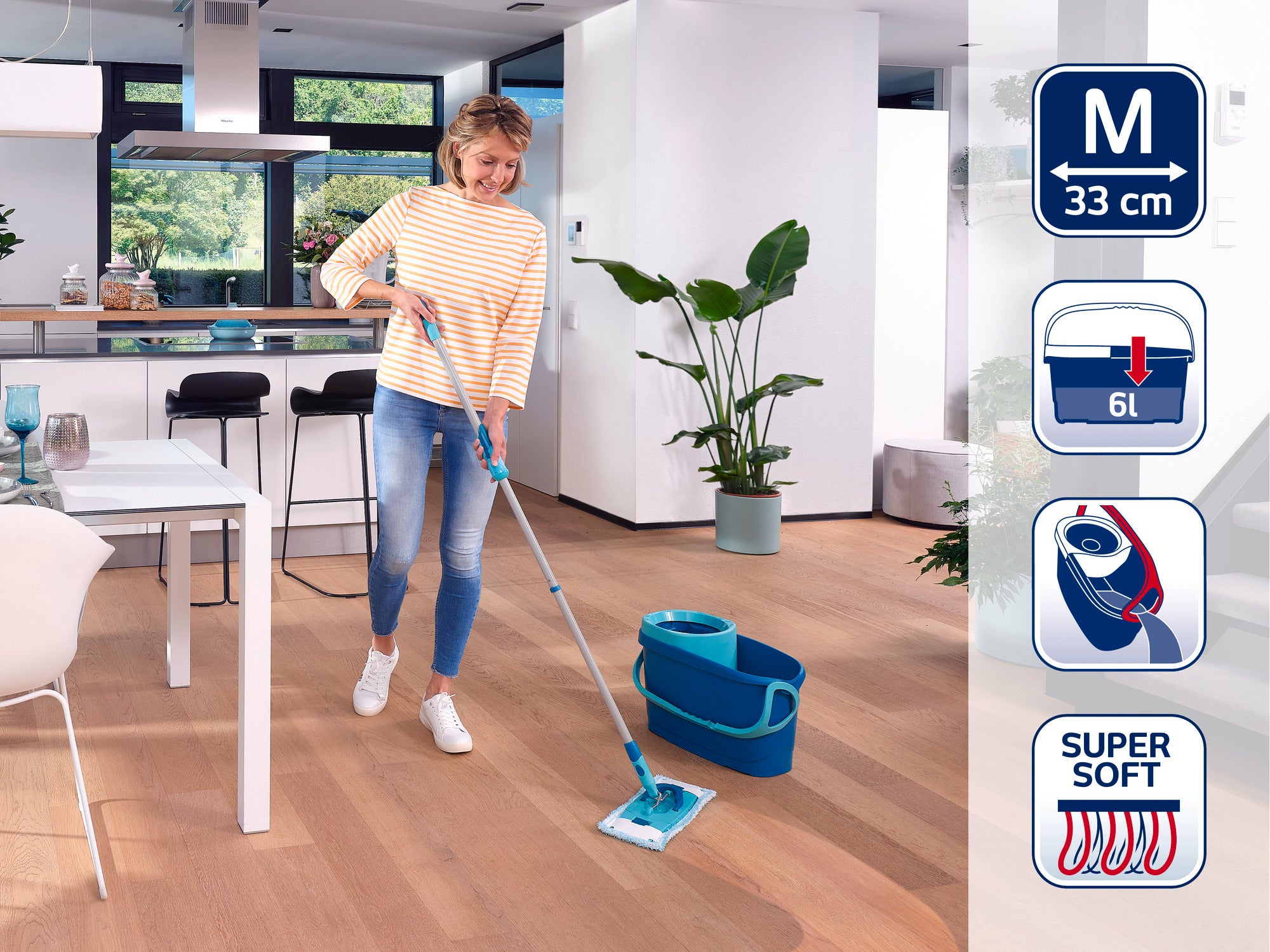 Een vrouw dweilt de houten vloer in een moderne keuken met een Leifheit dweilmop. De mop heeft een 33 cm brede kop en wordt gebruikt met een emmer van 6 liter.