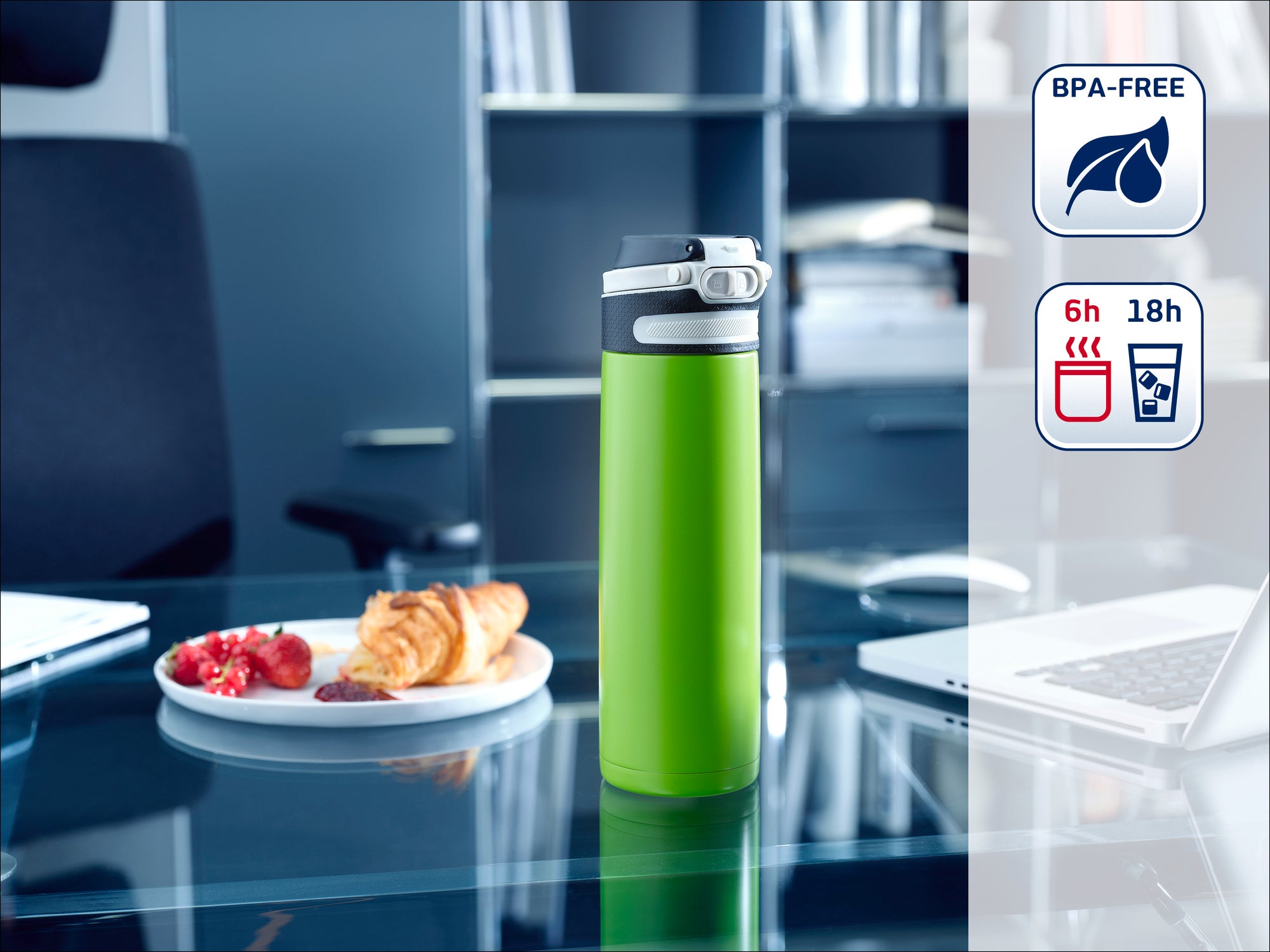 Eine grüne Thermosflasche steht auf einem modernen Büroschreibtisch. Im Hintergrund sind ein Laptop, ein Teller mit Gebäck und ein Regal zu sehen. Die Flasche ist BPA-frei und hält Getränke 6 Stunden heiß und 18 Stunden kalt.