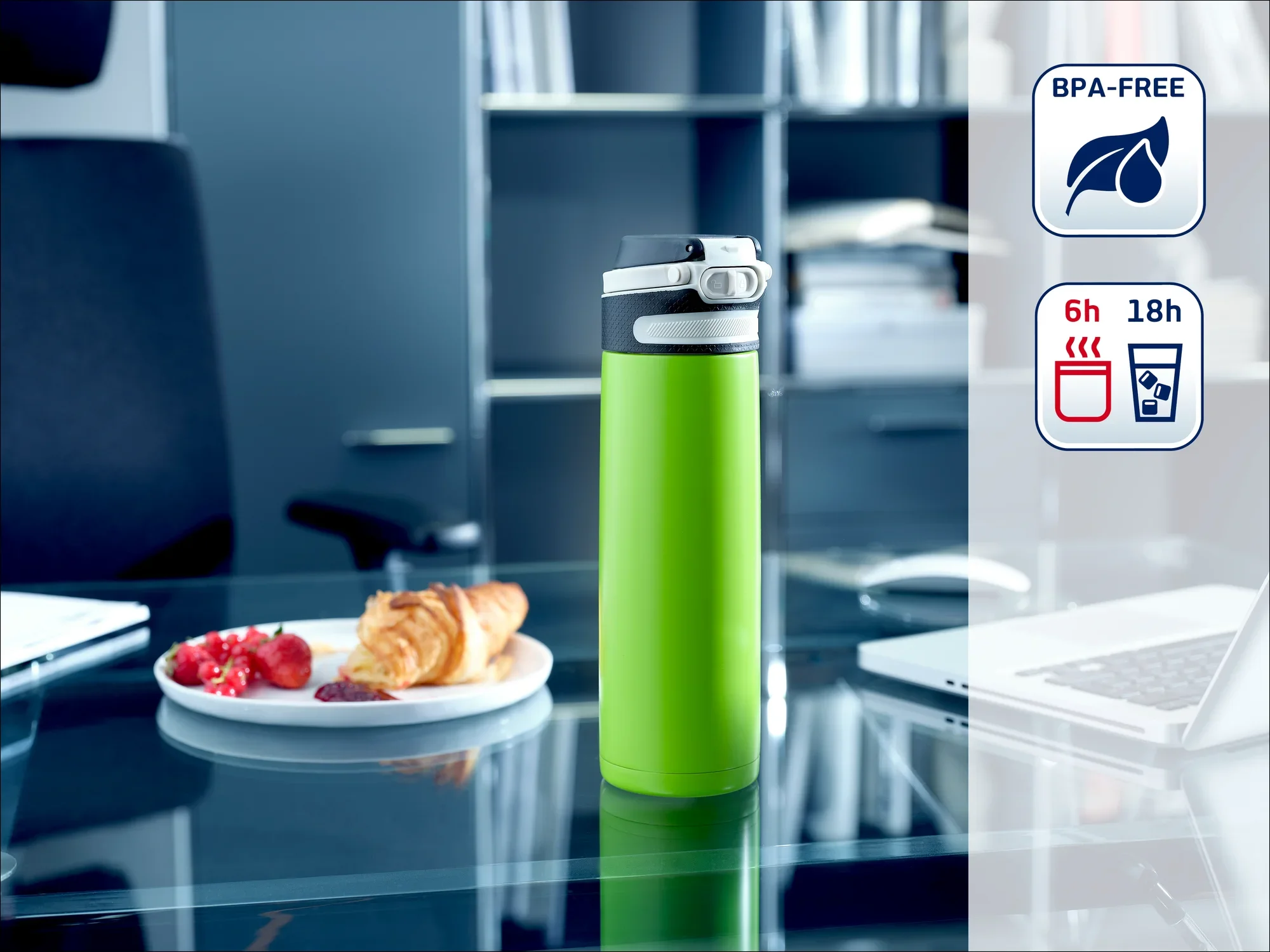 Zielony termos stoi na nowoczesnym biurku. W tle widać laptop, talerz z herbatnikami i półkę. Butelka jest wolna od BPA i utrzymuje napoje gorące przez 6 godzin, a zimne przez 18 godzin.