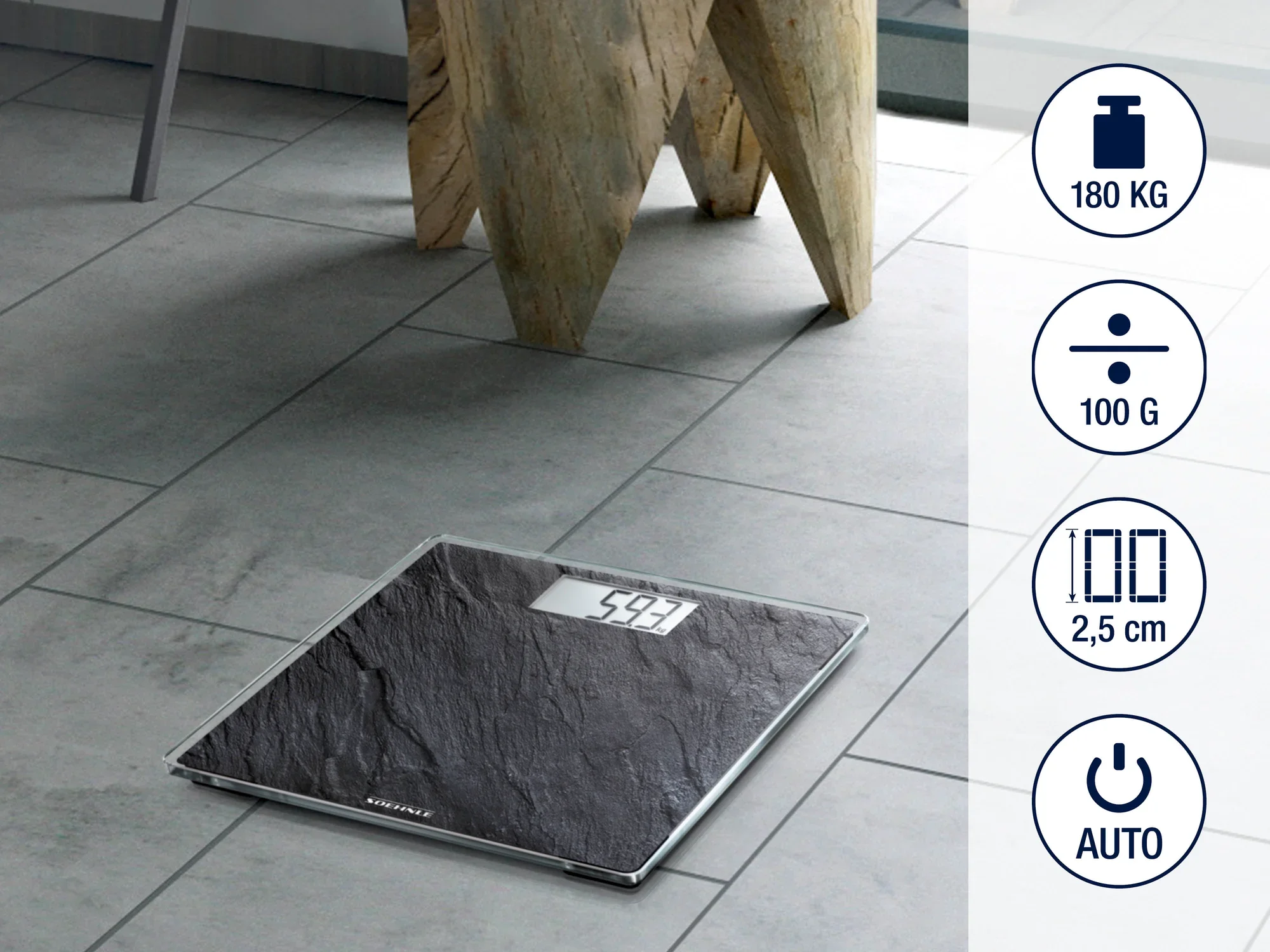 Cyfrowa waga łazienkowa na podłodze wyłożonej kafelkami. Waga ma maksymalny udźwig 180 kg, mierzy w krokach co 100 g i ma wysokość 2,5 cm. Funkcja automatycznego włączania.