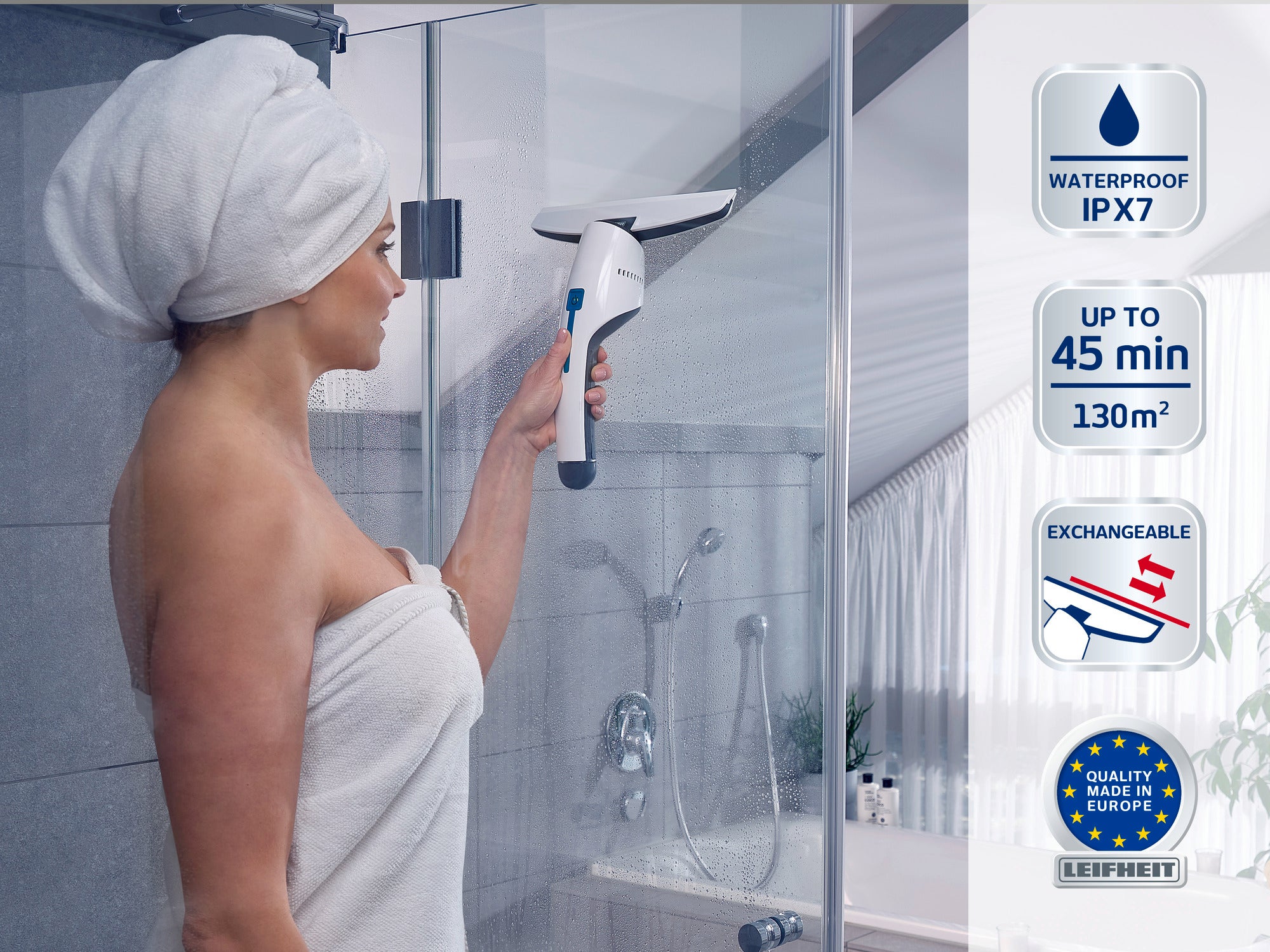 Una donna in asciugamano utilizza un aspirapolvere per vetri in una doccia moderna. L'aspirapolvere è impermeabile (IPX7), ha un'autonomia fino a 45 minuti ed è adatto per 130 m². Marchio di qualità "Made in Europe" visibile.