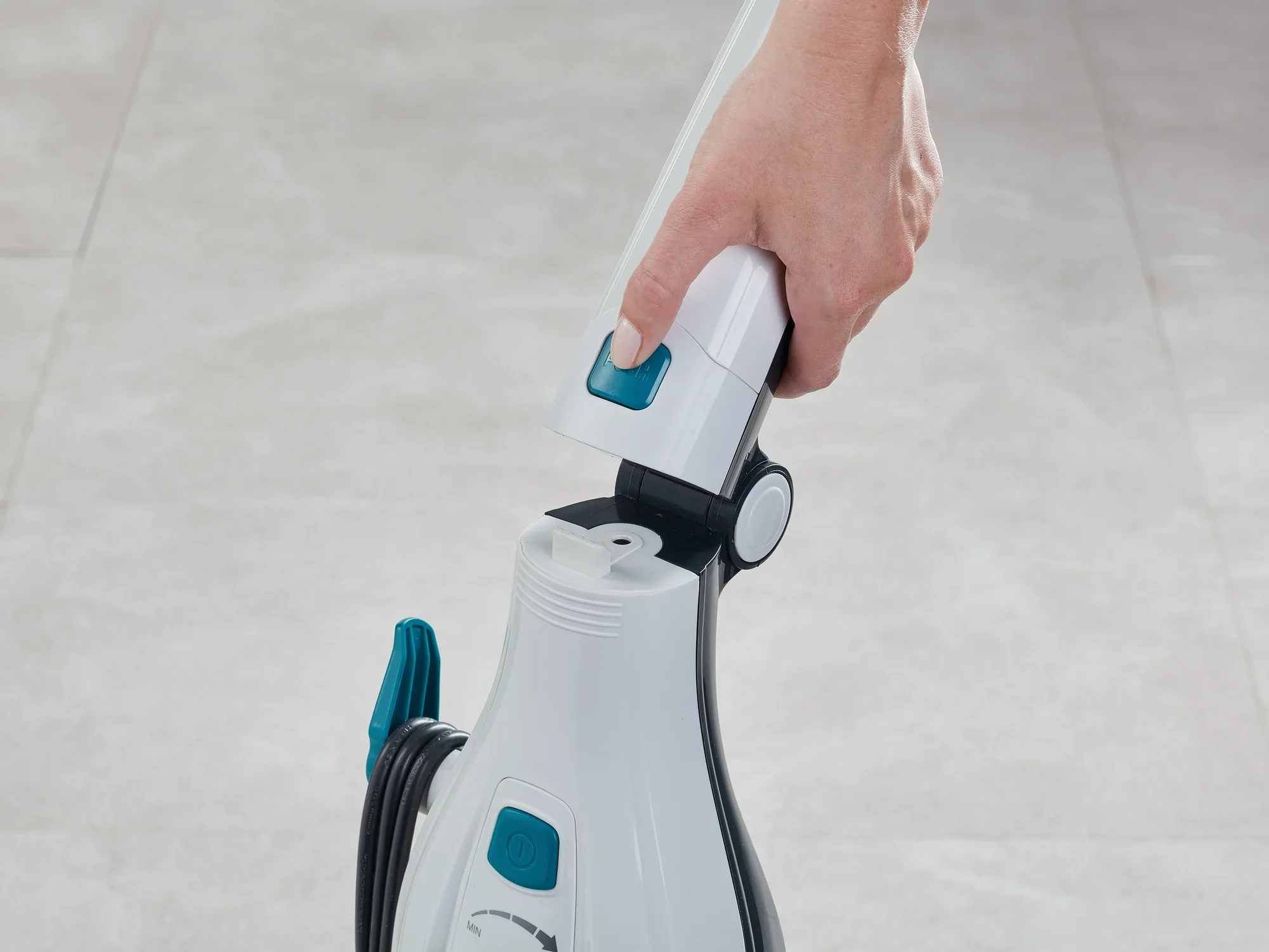 Dampfreiniger Clean Tenso in Anwendung. Eine Hand hält den Griff des Geräts, das auf einem hellen Boden steht. Der Dampfreiniger ist weiß mit blauen Akzenten.