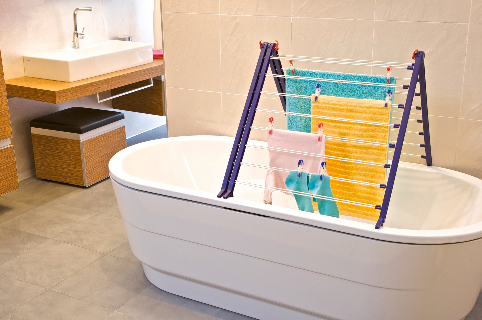 Suszarka Pegasus Bath 190 Extendable sprawdzi się w nowoczesnej łazience. Suszarka jest umieszczona nad wanną i mieści kolorowe ręczniki.