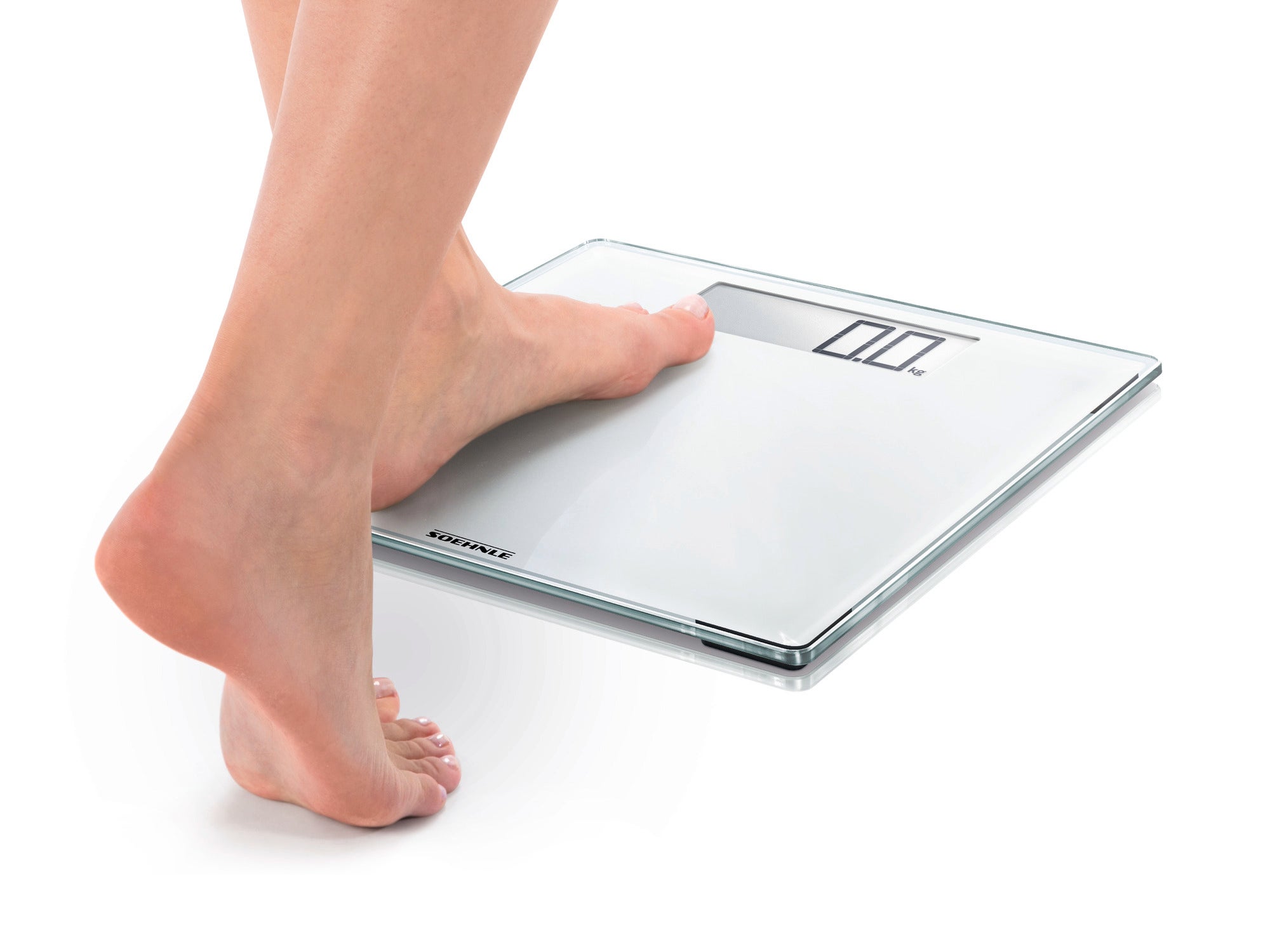 Eine Person steht barfuß auf einer digitalen Personenwaage, Modell Style Sense Comfort 100. Die Waage hat ein modernes, flaches Design mit einem gut lesbaren Display.