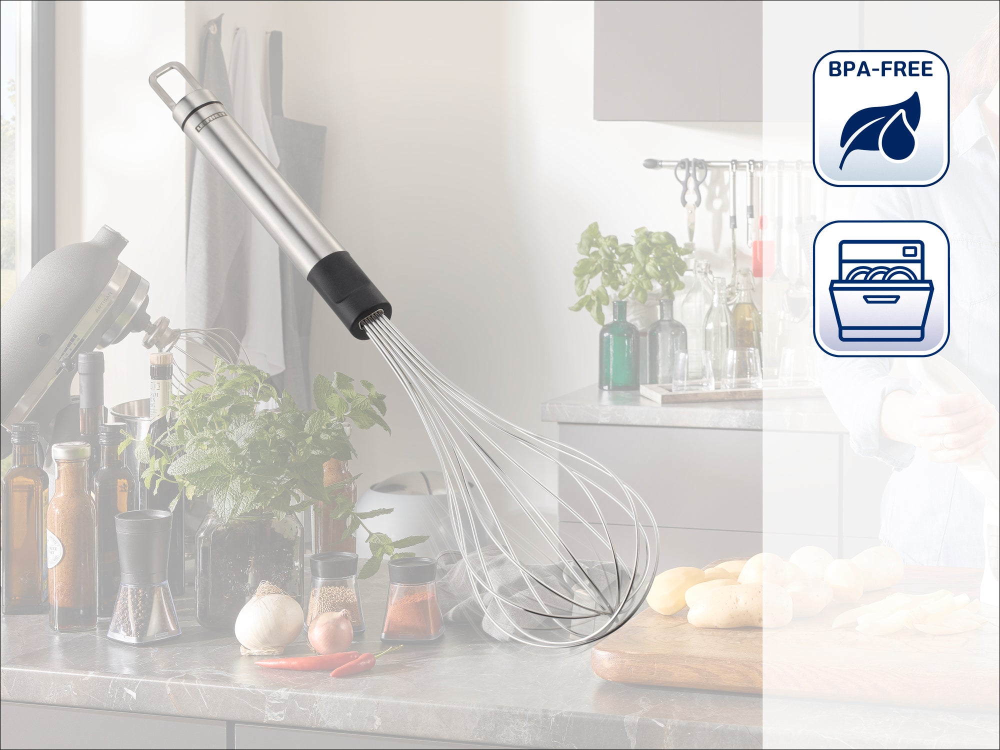 A stainless steel whisk hangs in a modern kitchen. Fresh ingredients and kitchen utensils can be seen in the background. Symbols indicate that it is BPA-free and dishwasher safe.