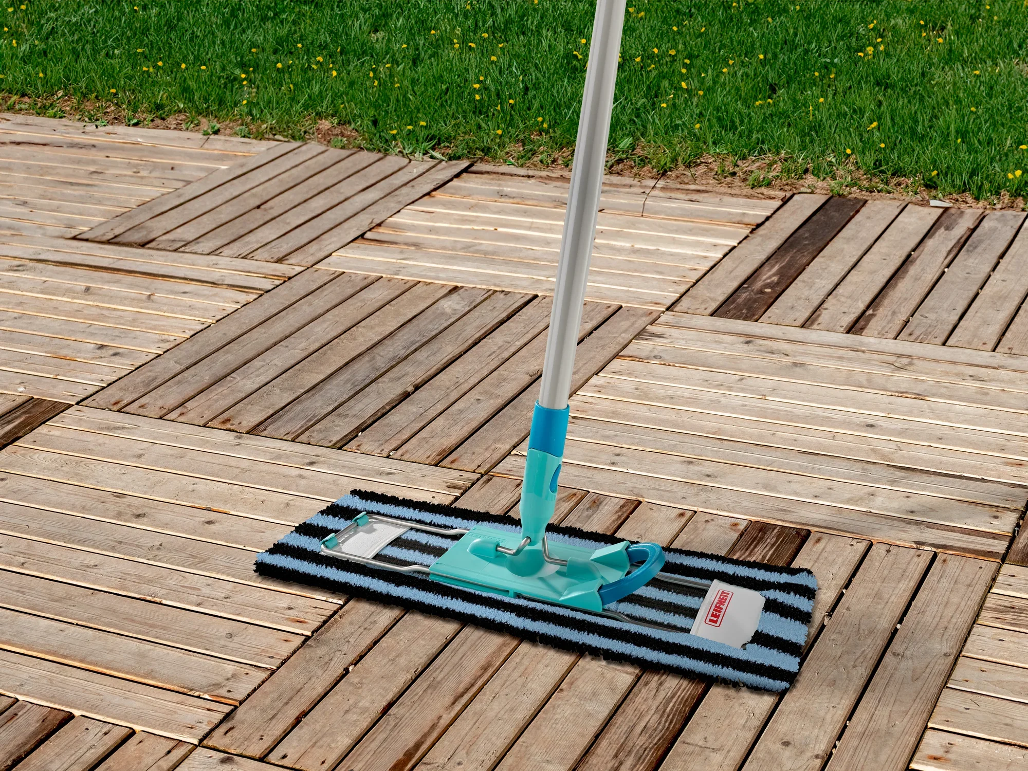 Profi XL Outdoor mopovertrek op een houten terras. De overtrek is blauw en zwart gestreept en wordt gebruikt met een steel. Ideaal voor het schoonmaken van buitenruimtes.