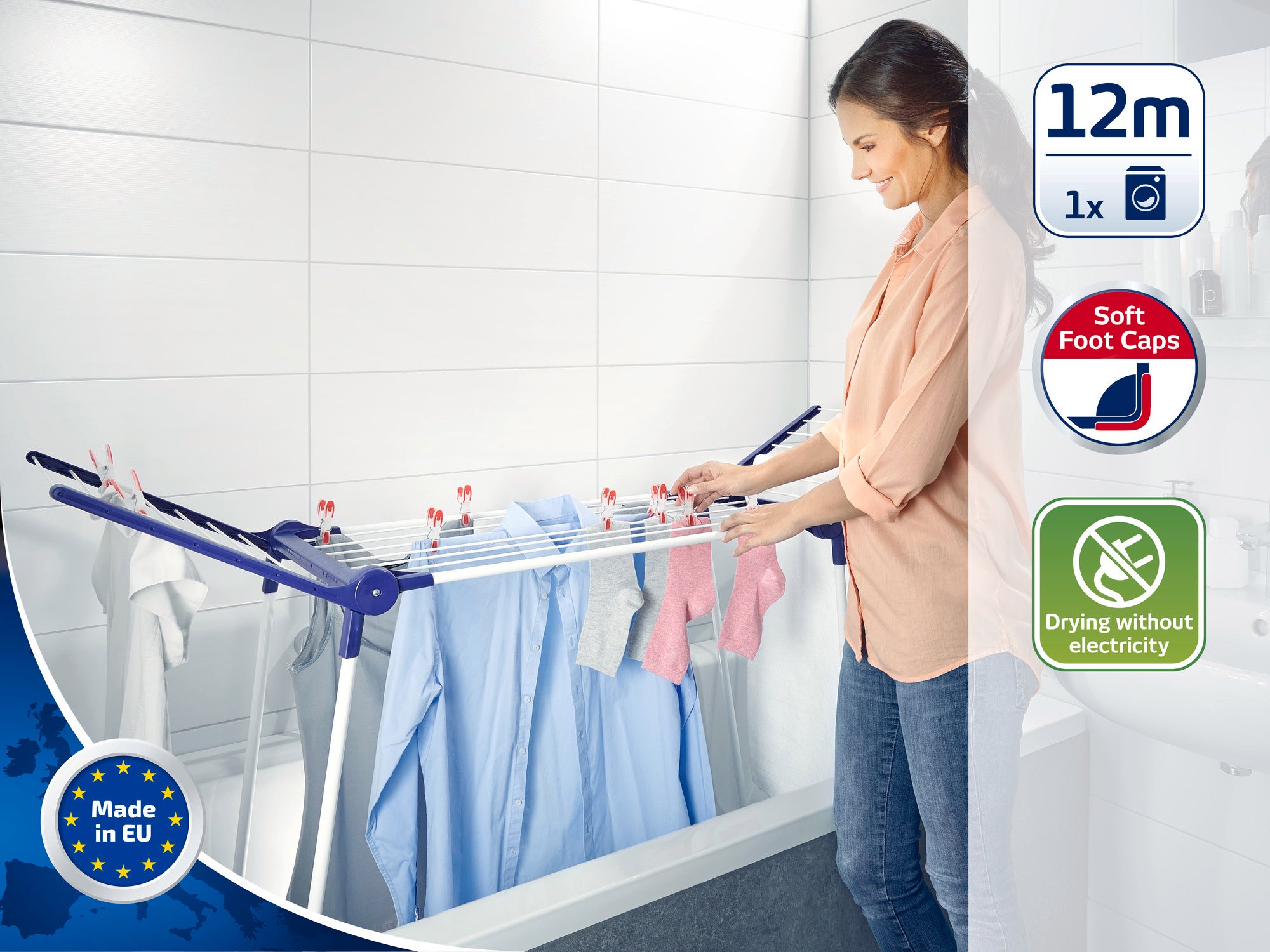 Kobieta używa suszarki stojącej w łazience. Suszarka ma miękkie nóżki i oferuje 12 metrów długości suszenia. Idealna do suszenia bez użycia prądu. Wyprodukowano w UE.
