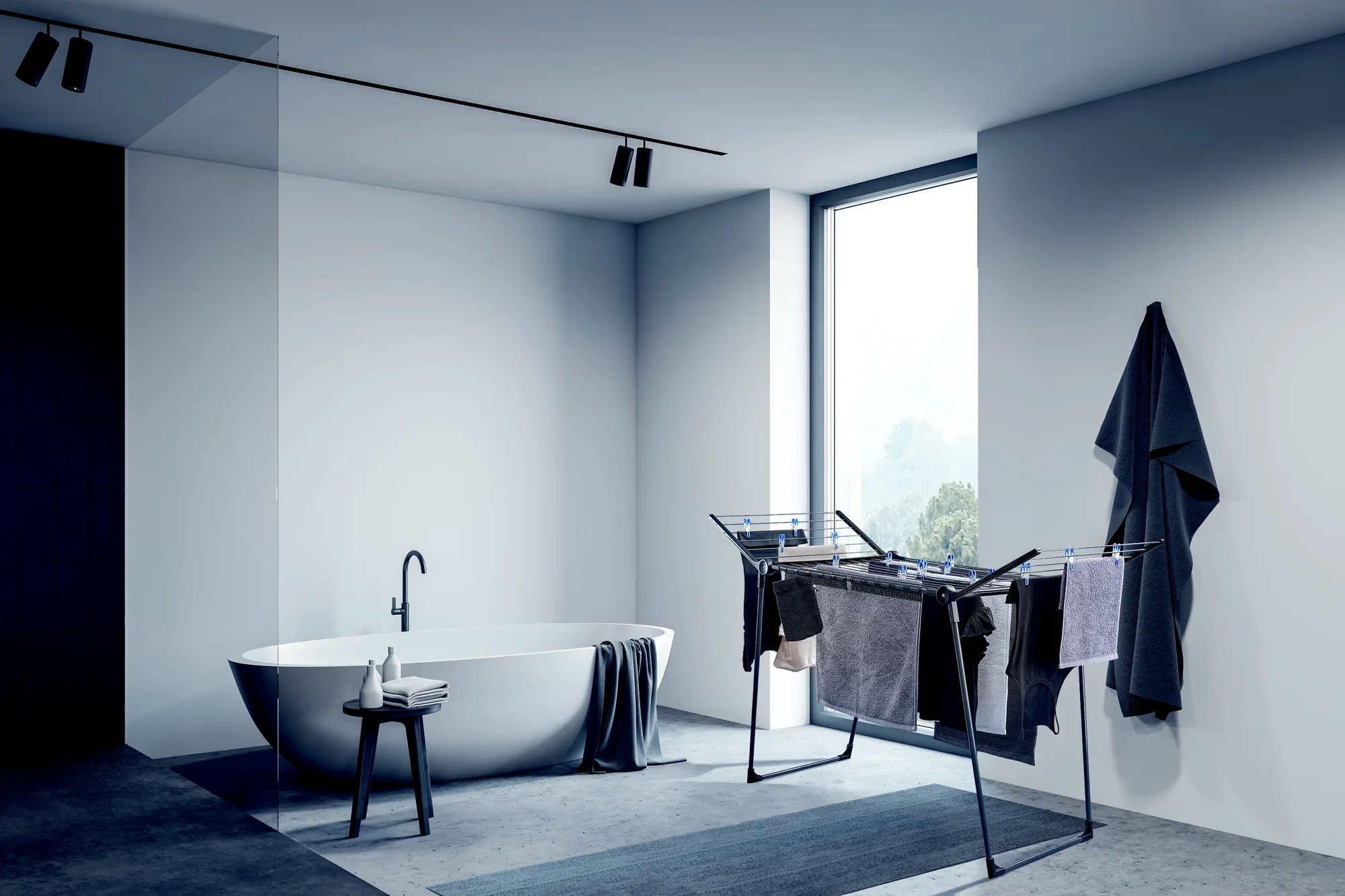 Nowoczesny, minimalistyczny pokój z wolnostojącą suszarką bębnową Pegasus 180 Solid. Suszarka jest załadowana ubraniami i stoi obok wolnostojącej wanny.