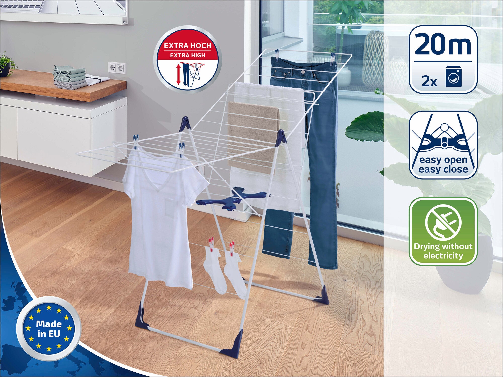 Een vrijstaande droger in een moderne kamer met een houten vloer. De droger biedt 20 meter drooglengte en is extra hoog voor grote stukken wasgoed. Gemaakt in Europa.