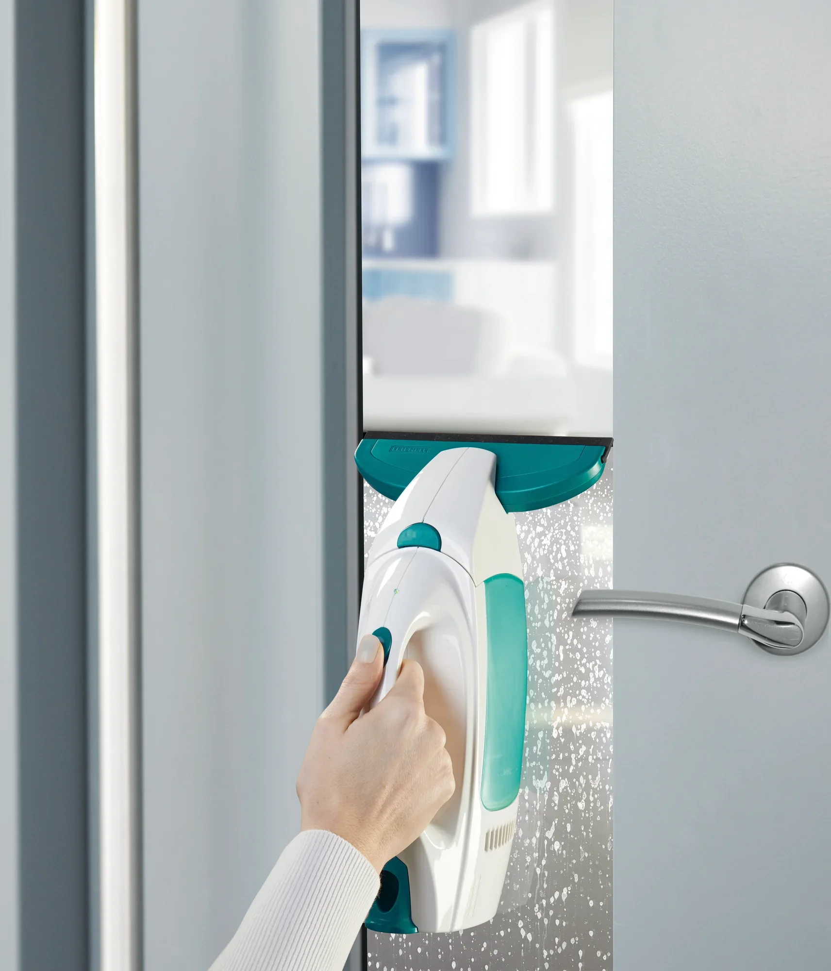 Fenstersauger Dry and Clean mit kleiner Düse reinigt eine Glastür. Eine Hand hält den Sauger, während er Wasser und Schmutz effizient entfernt. Ideal für streifenfreie Fenster.