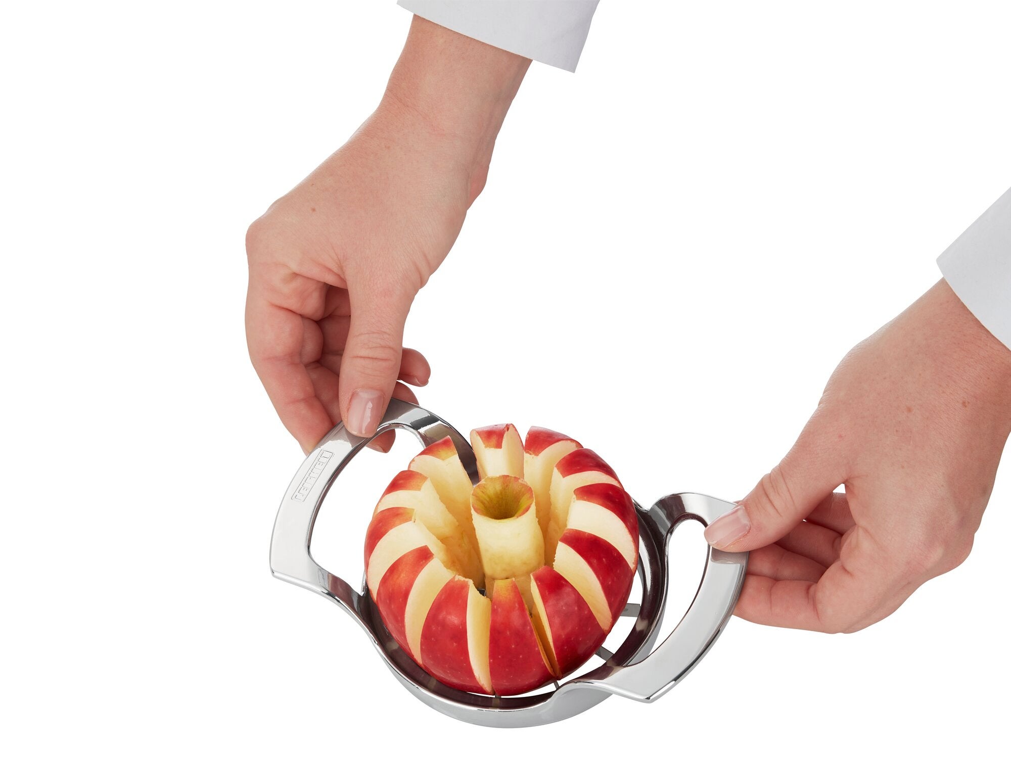 Ein Apfelschneider wird verwendet, um einen Apfel in gleichmäßige Scheiben zu schneiden. Zwei Hände halten den Schneider, während der Apfel in der Mitte positioniert ist.