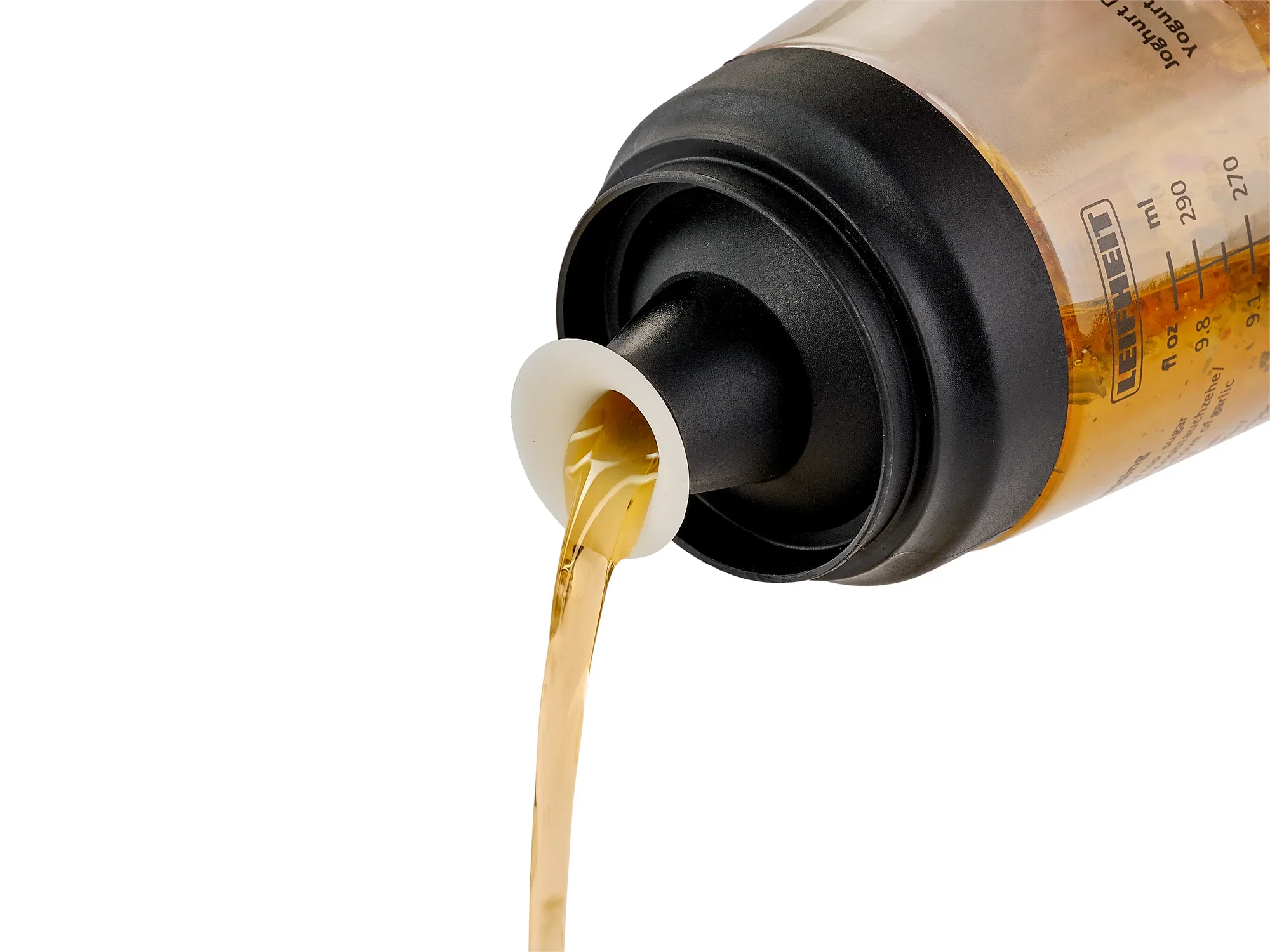 Een saladedressing shaker is in actie te zien. Een gouden vloeistof wordt uit de shaker gegoten, wat het praktische gebruik en de functionaliteit van het product benadrukt.