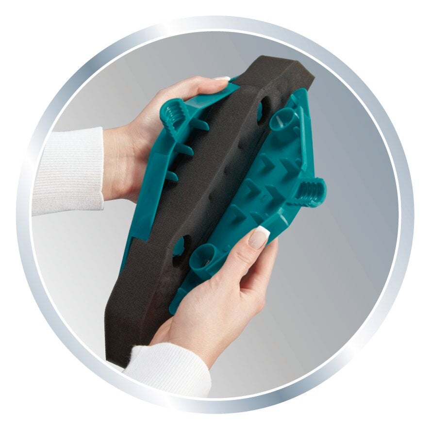 Un paio di mani reggono la schiuma di ricambio Soft&Easy, presentata in una cornice rotonda. La schiuma è nera con elementi in plastica blu.