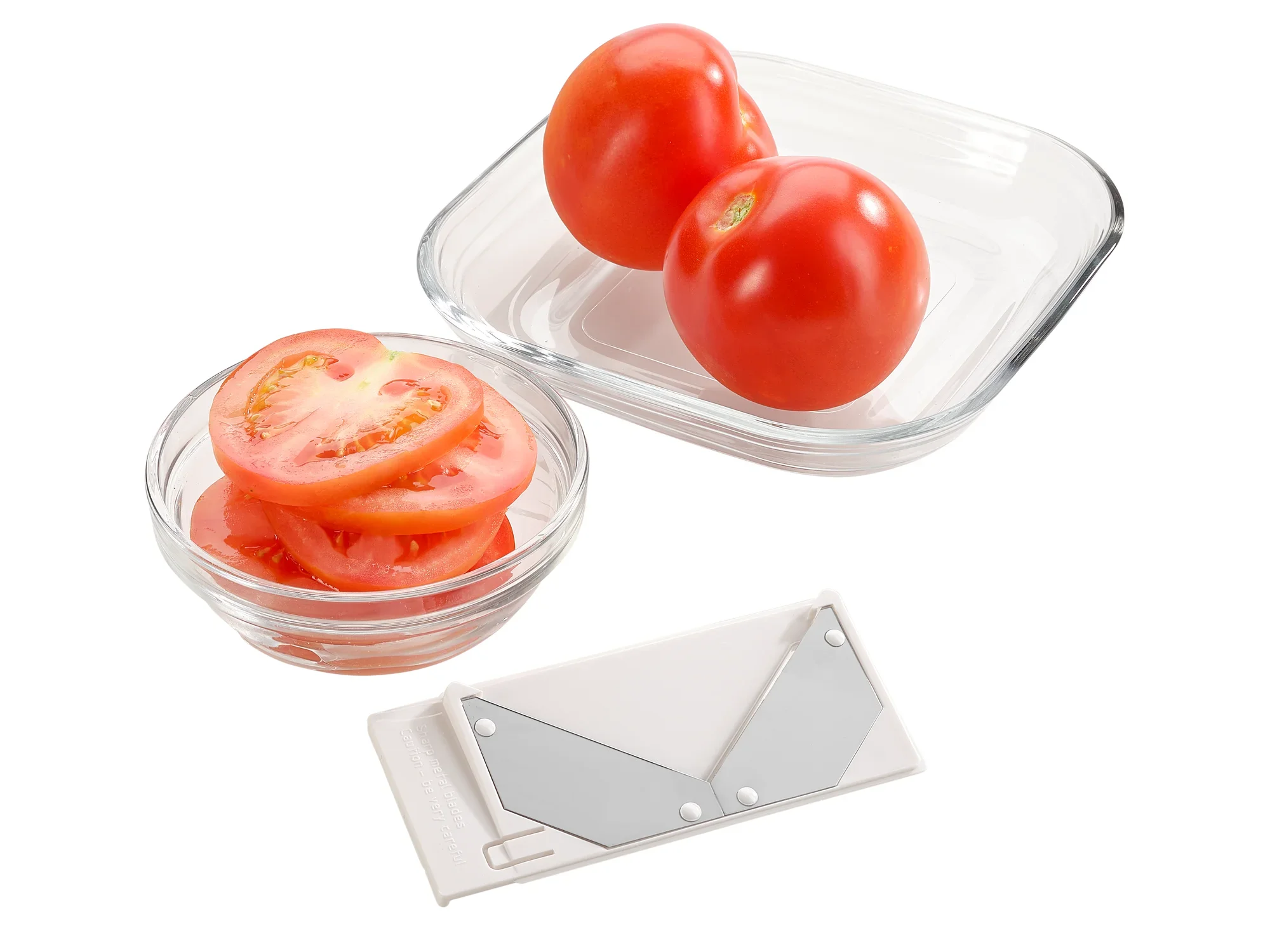 Op de foto zie je de allesrasp met 4+1 toepassingen. Twee hele tomaten en gesneden tomaten in glazen schaaltjes illustreren de veelzijdigheid van de rasp.