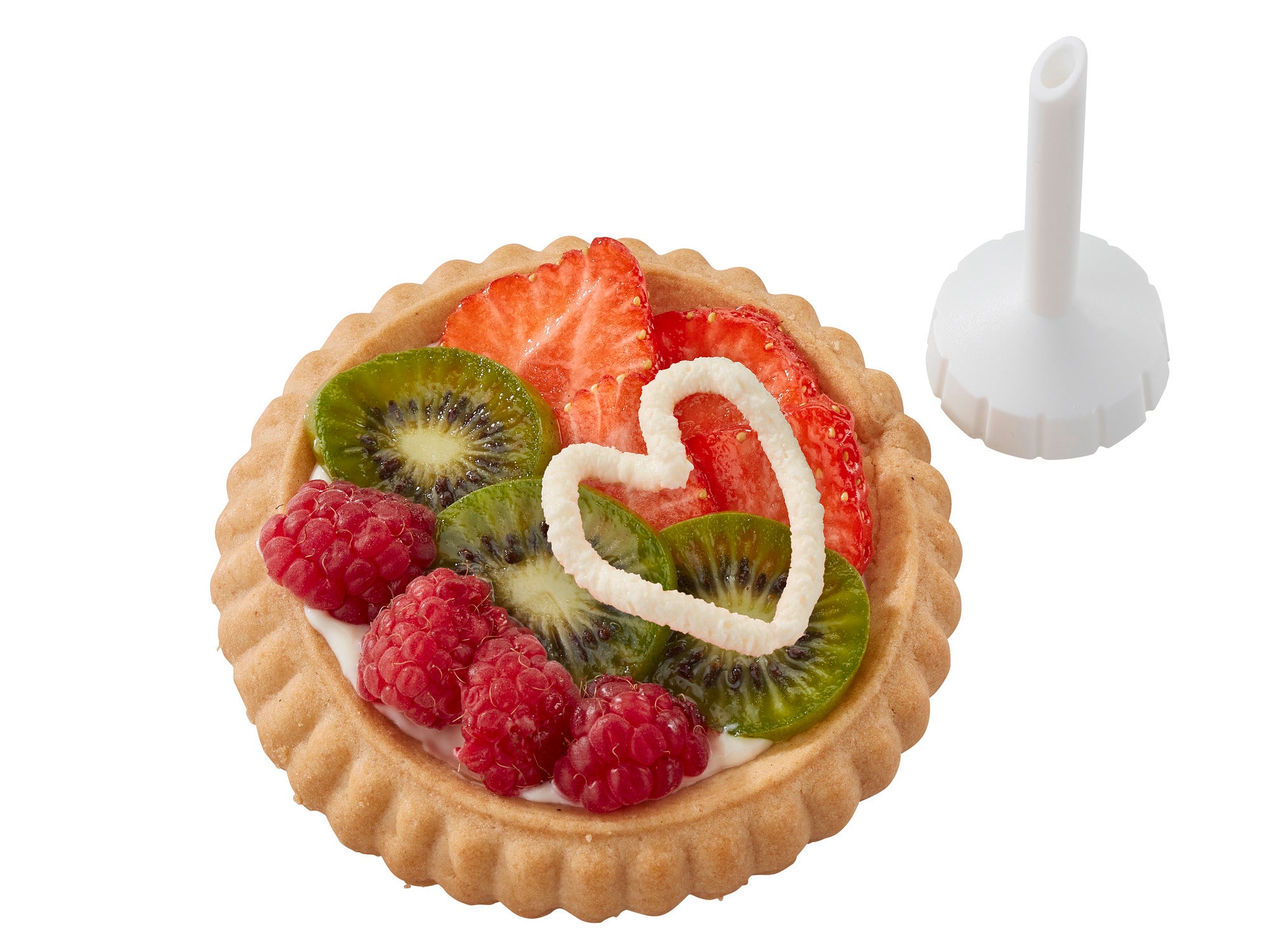 Ein dekorierter Obstkuchen mit Erdbeeren, Kiwi und Himbeeren, verziert mit einer Sahneherzform. Daneben liegt eine Düse aus einem Spritzbeutel-Set zur Dekoration.