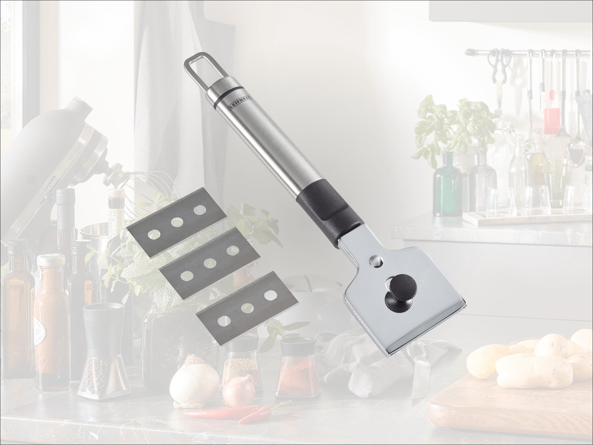 Un raschietto da cucina in acciaio inossidabile di alta qualità con impugnatura ergonomica, raffigurato con tre lame di ricambio. Ideale per rimuovere i residui ostinati dai piani cottura.