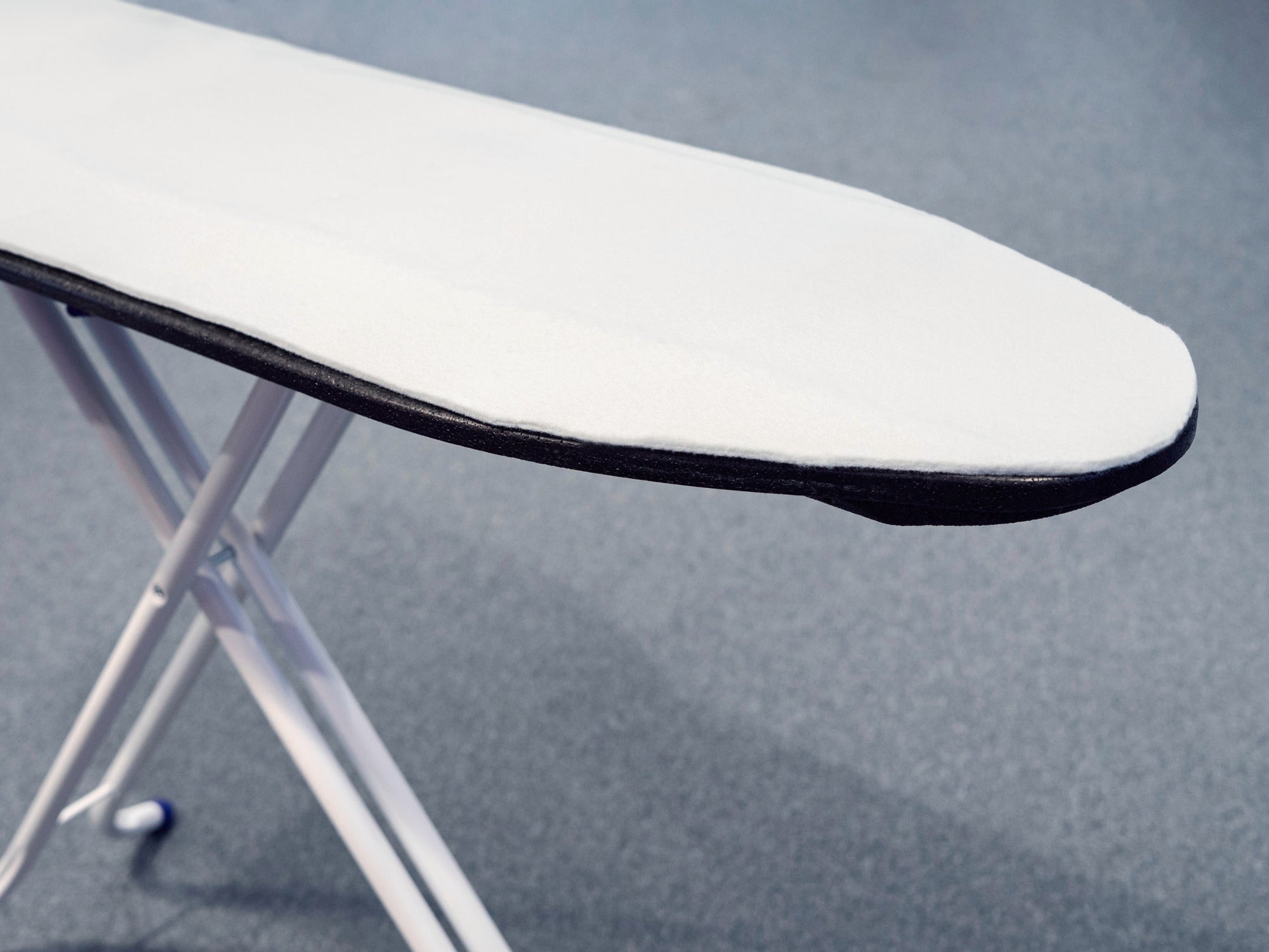 Ironing board padding on an ironing board. The padding is white and fits the shape of the ironing board perfectly to ensure a smooth ironing experience.