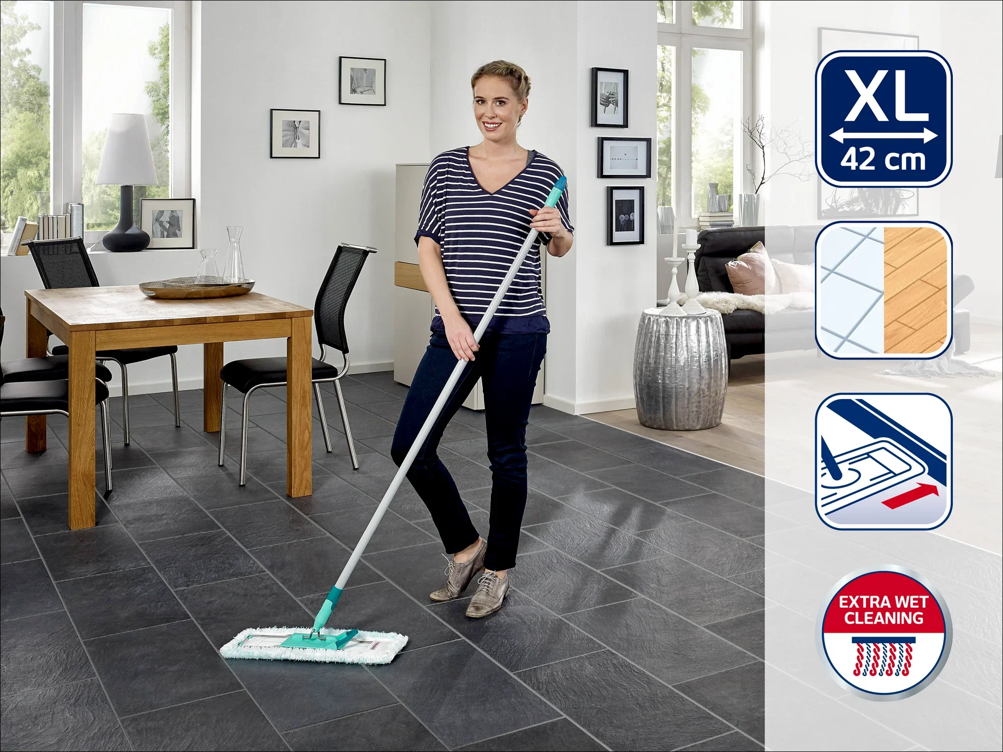 Una donna pulisce il pavimento con un lavapavimenti Leifheit. Il lavapavimenti ha un panno XL largo 42 cm. Sullo sfondo si vede una zona pranzo con tavolo e sedie.
