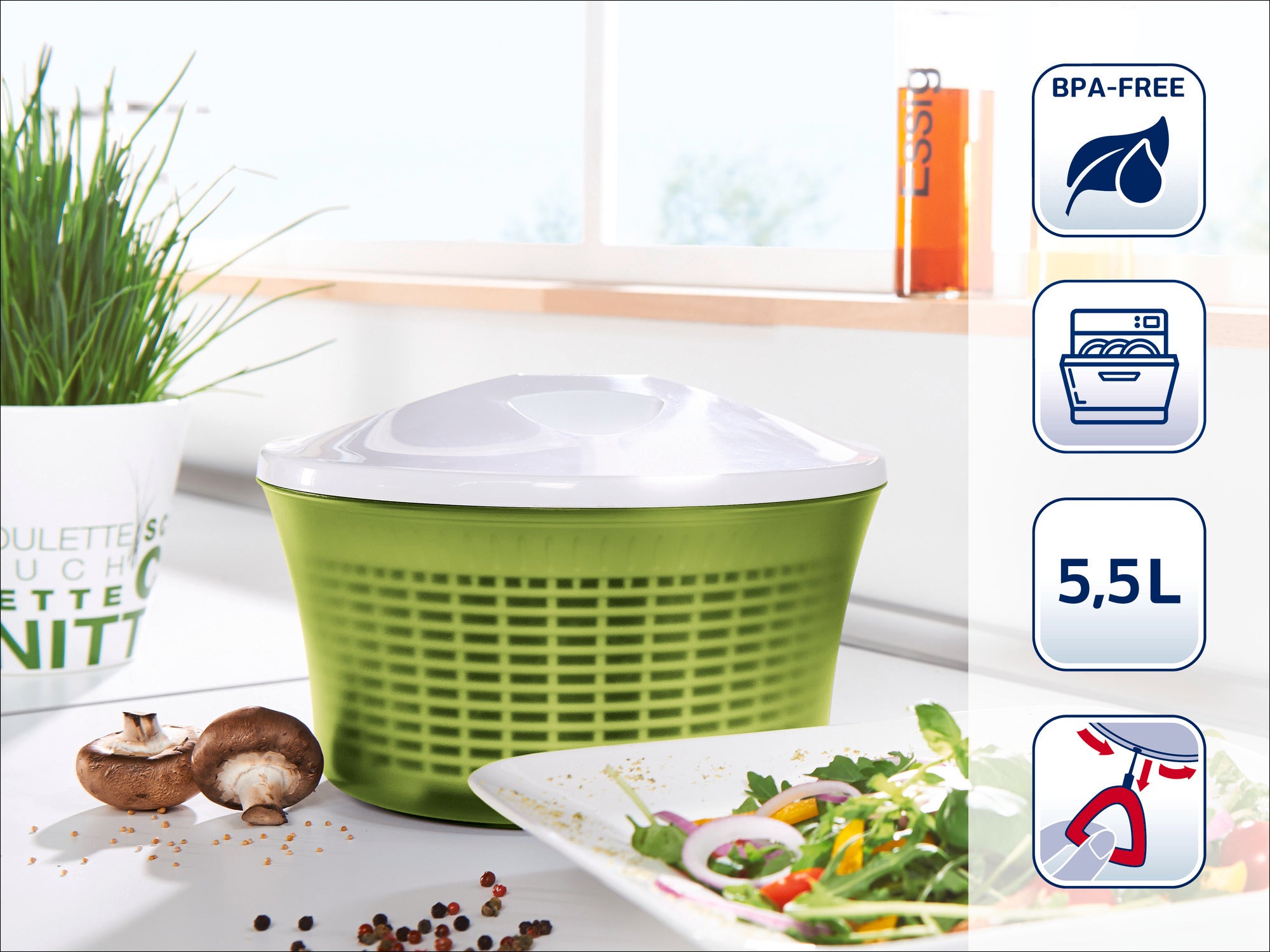 Salatschleuder in einer modernen Küche. Das grüne Design mit weißem Deckel ist BPA-frei, spülmaschinengeeignet und hat ein Fassungsvermögen von 5,5 Litern. Ideal für frische Salate.