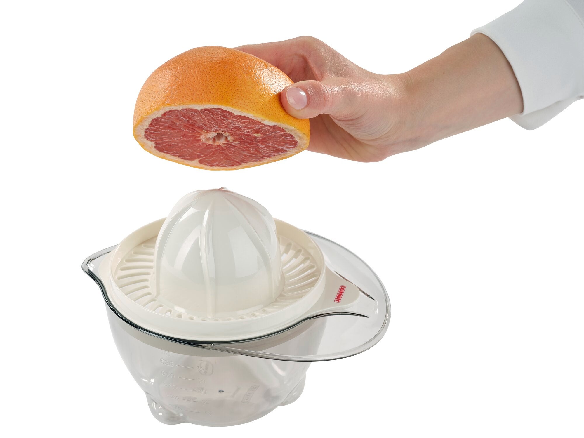 Eine Hand hält eine halbe Grapefruit über eine Zitruspresse. Die Zitruspresse hat einen weißen Kegel und eine transparente Auffangschale, ideal zum Entsaften von Zitrusfrüchten.