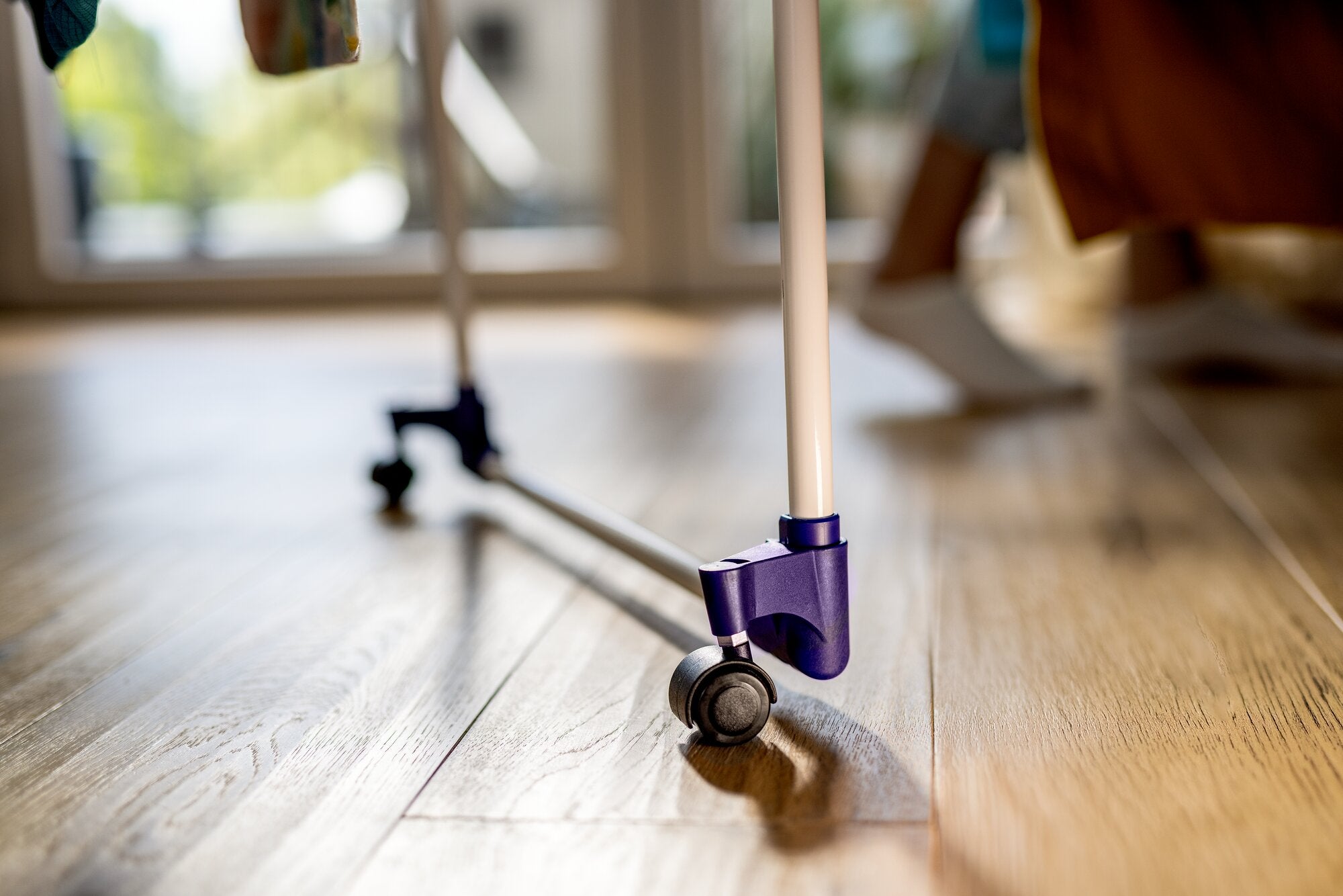Leifheit Pegasus Ultra Mobile 23 m Wäscheständer mit leichtgängiger Rolle am Standbein auf hellem Holzboden in Wohnraum-Nähe; Detailaufnahme zeigt die mobile Konstruktion für flexibles Verschieben.