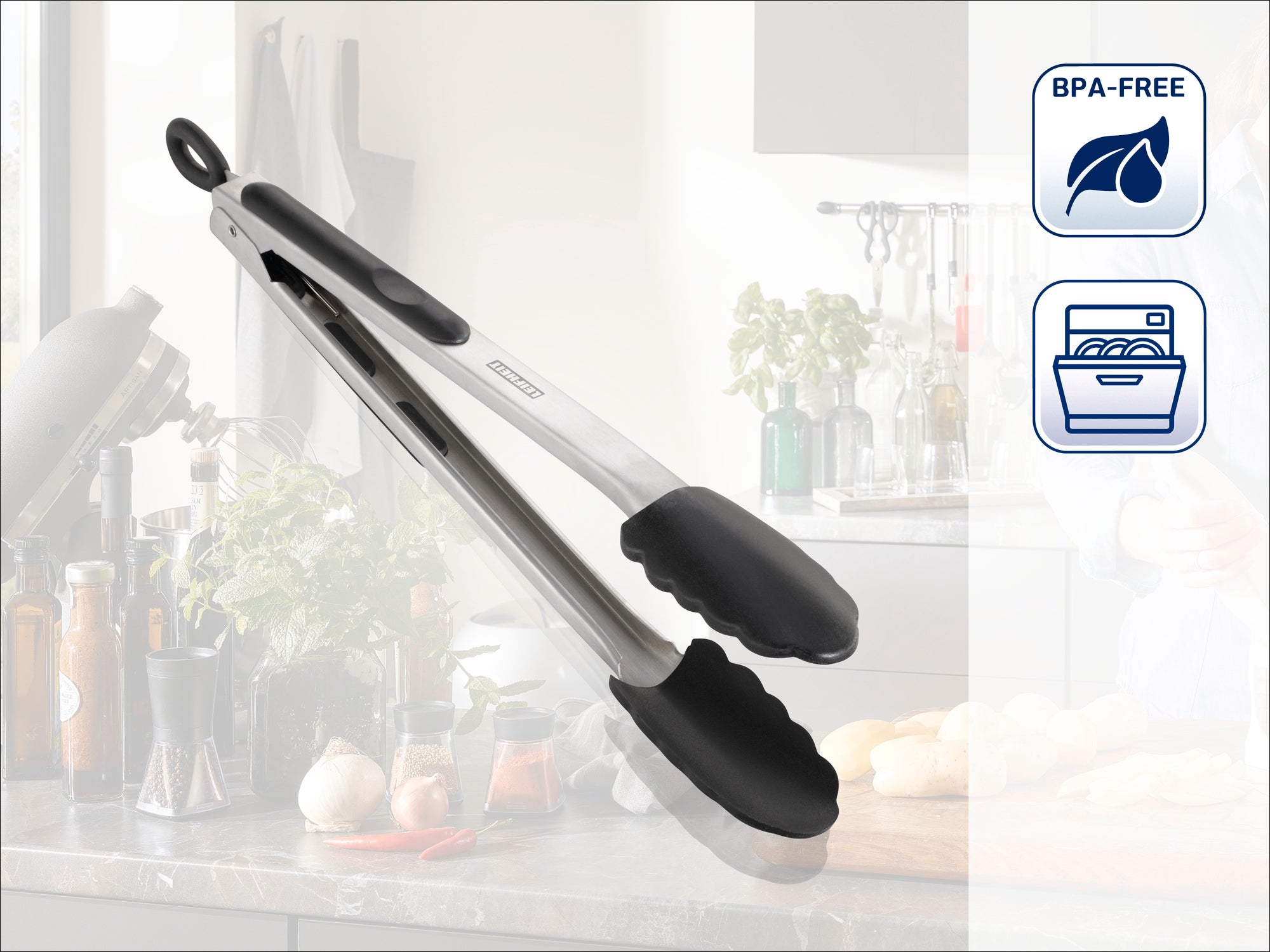 Pince de cuisine en acier inoxydable avec pointes en silicone noir, idéale pour saisir les aliments. Sans BPA et lavable au lave-vaisselle, présentée dans une cuisine moderne.