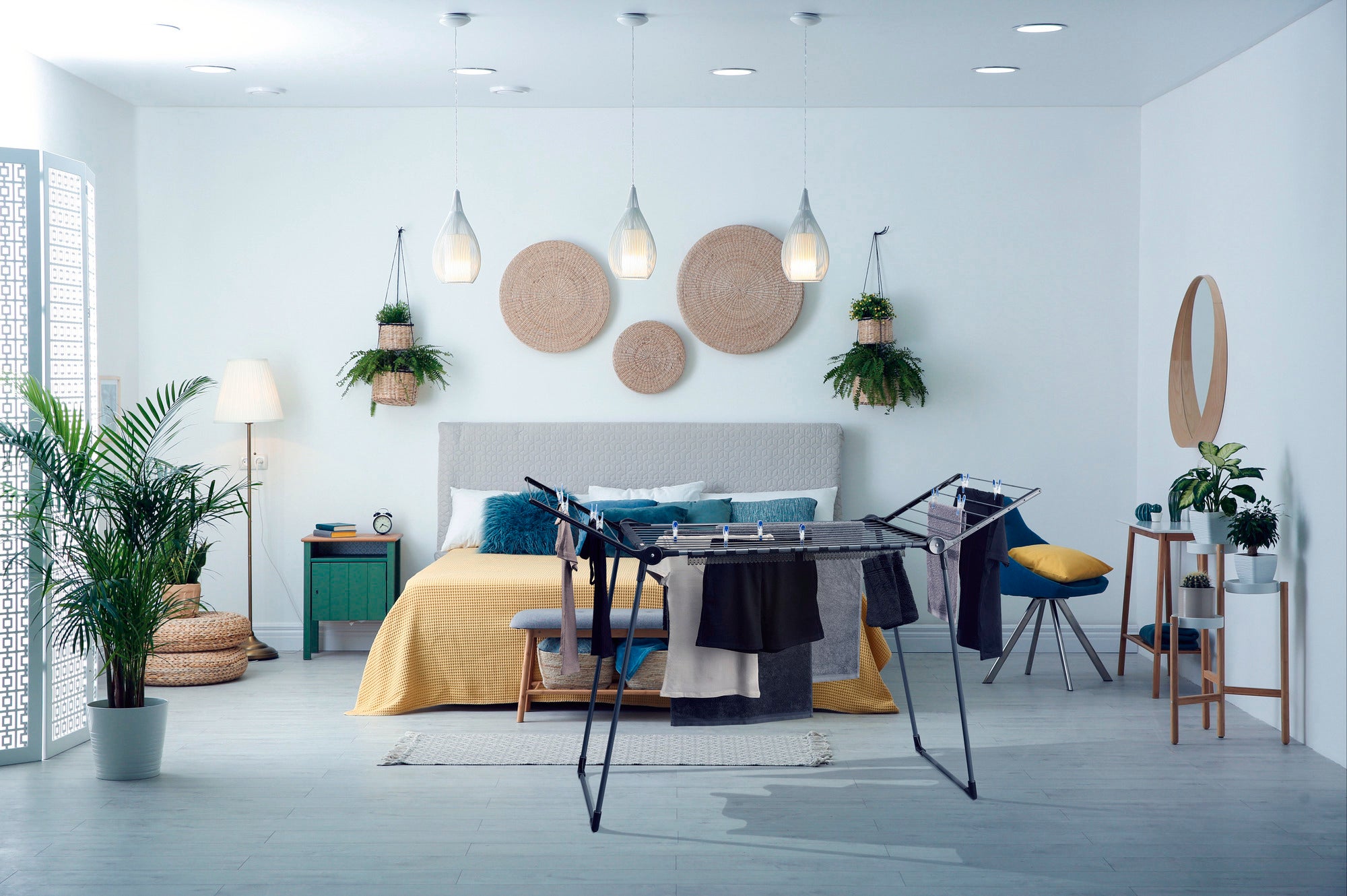 Wolnostojąca suszarka bębnowa Pegasus 180 Solid w nowoczesnej sypialni. Suszarka bębnowa jest załadowana ubraniami i harmonijnie wtapia się w stylową atmosferę.