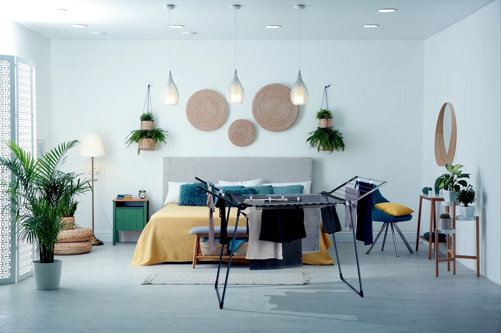 Wolnostojąca suszarka bębnowa Pegasus 180 Solid w nowoczesnej sypialni. Suszarka bębnowa jest załadowana ubraniami i harmonijnie wtapia się w stylową atmosferę.