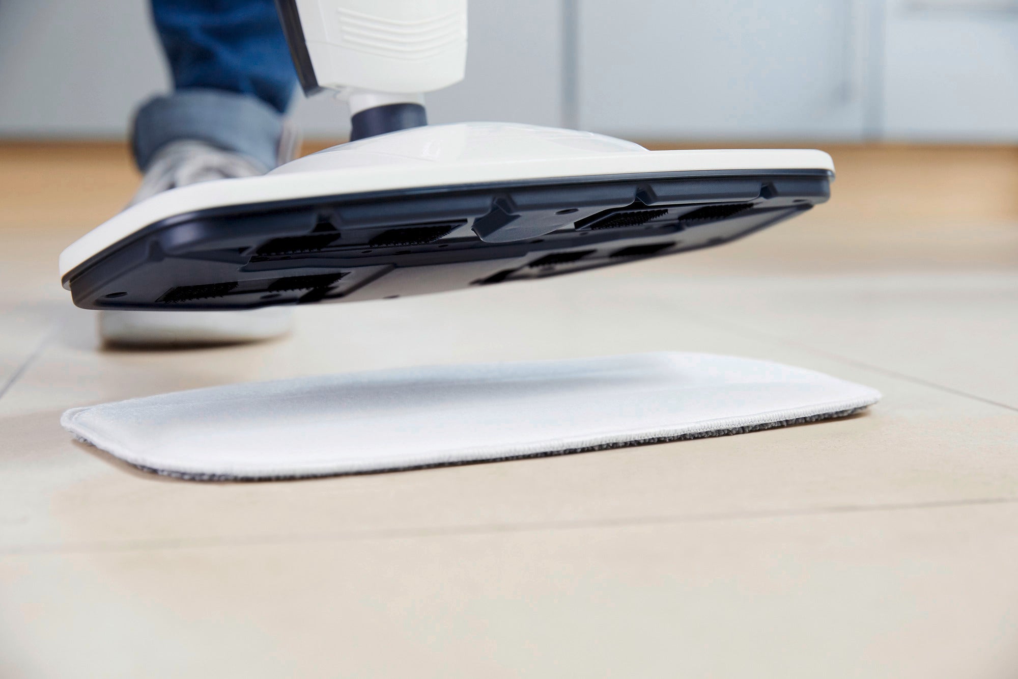 Dampfreiniger Clean Tenso in Aktion auf einem hellen Fliesenboden. Der weiße Dampfreiniger schwebt knapp über dem Boden und zeigt seine Reinigungsleistung.