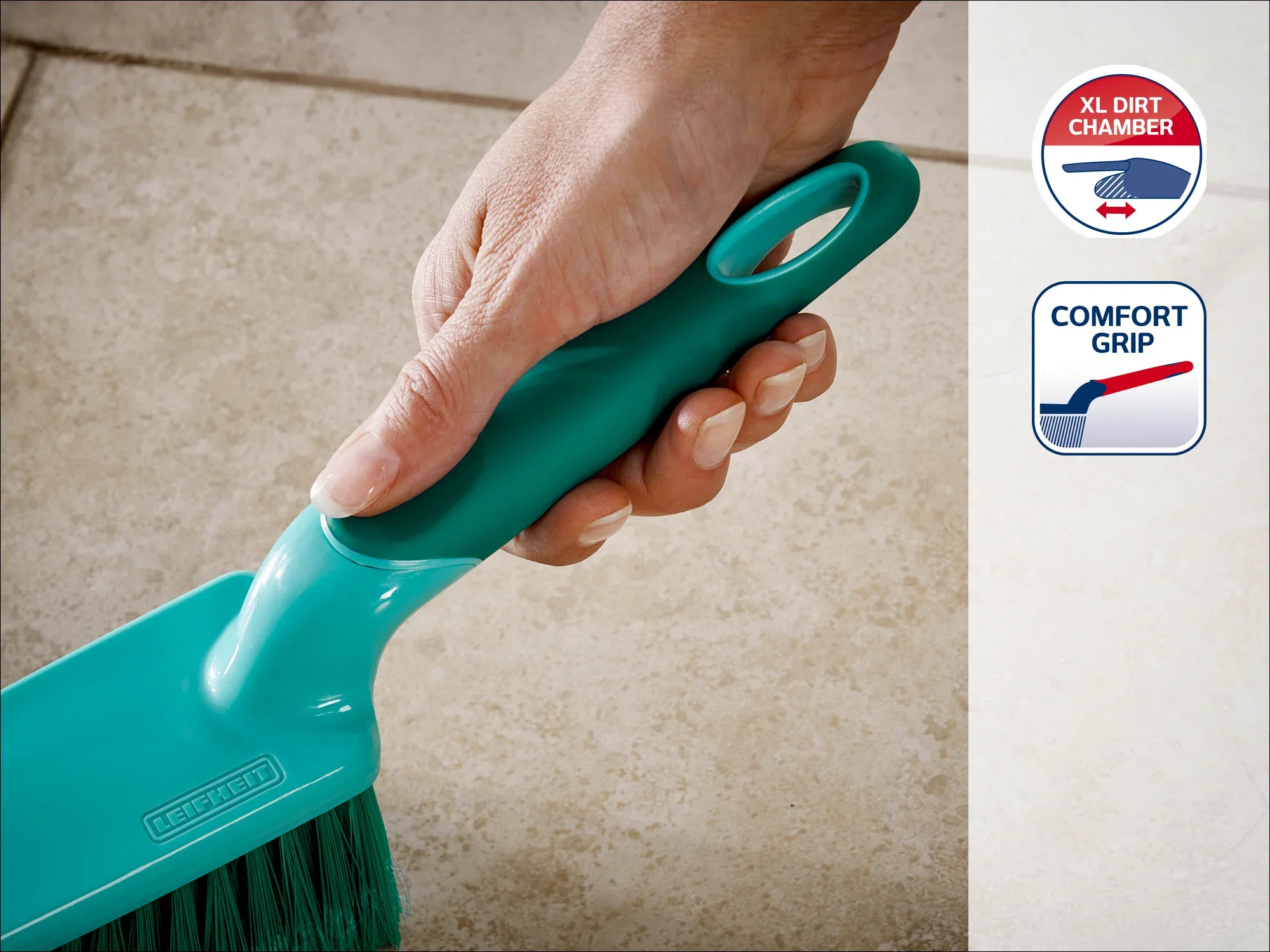 Eine Hand hält einen grünen Handfeger mit ergonomischem Griff, ideal für komfortables Kehren. Auf der Verpackung sind die Merkmale "XL Dirt Chamber" und "Comfort Grip" hervorgehoben.