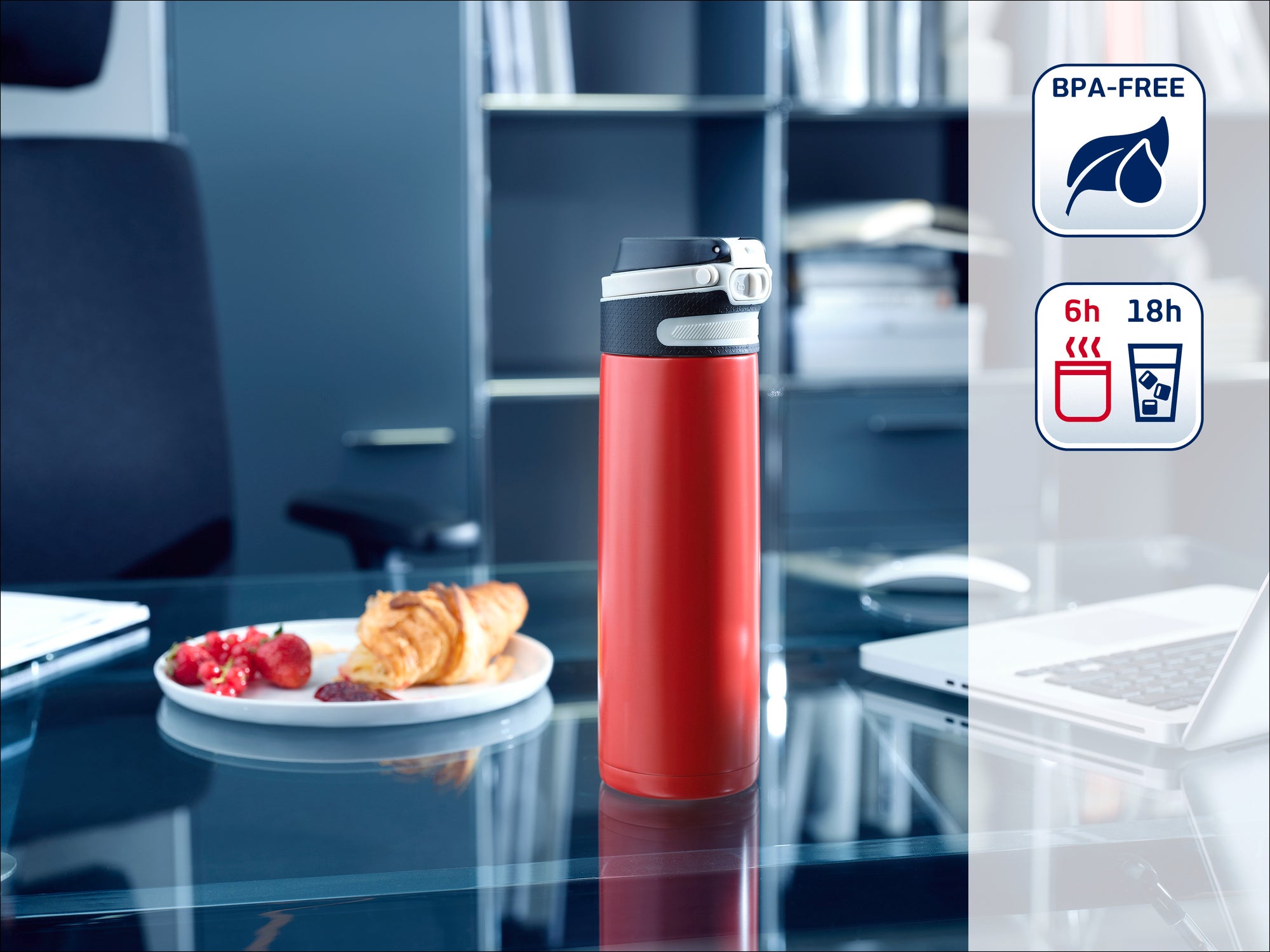 Une bouteille thermos rouge est posée sur un bureau moderne à côté d'une assiette de pâtisseries. Elle est sans BPA et garde les boissons chaudes pendant 6 heures et froides pendant 18 heures.