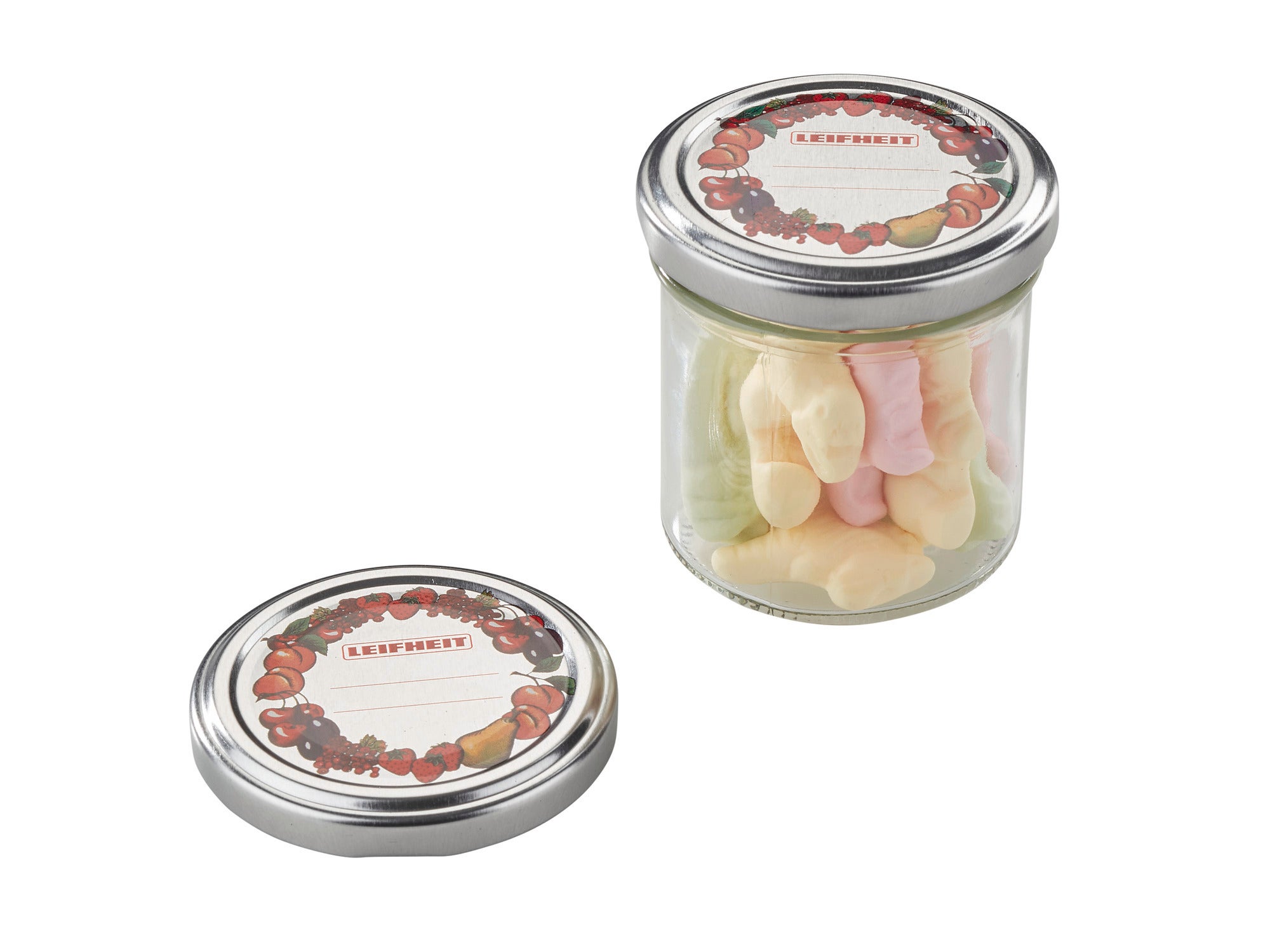 Un bocal contenant des bonbons colorés et un couvercle de rechange amovible de 66 mm de diamètre. Le couvercle est décoré d'un motif fruité.