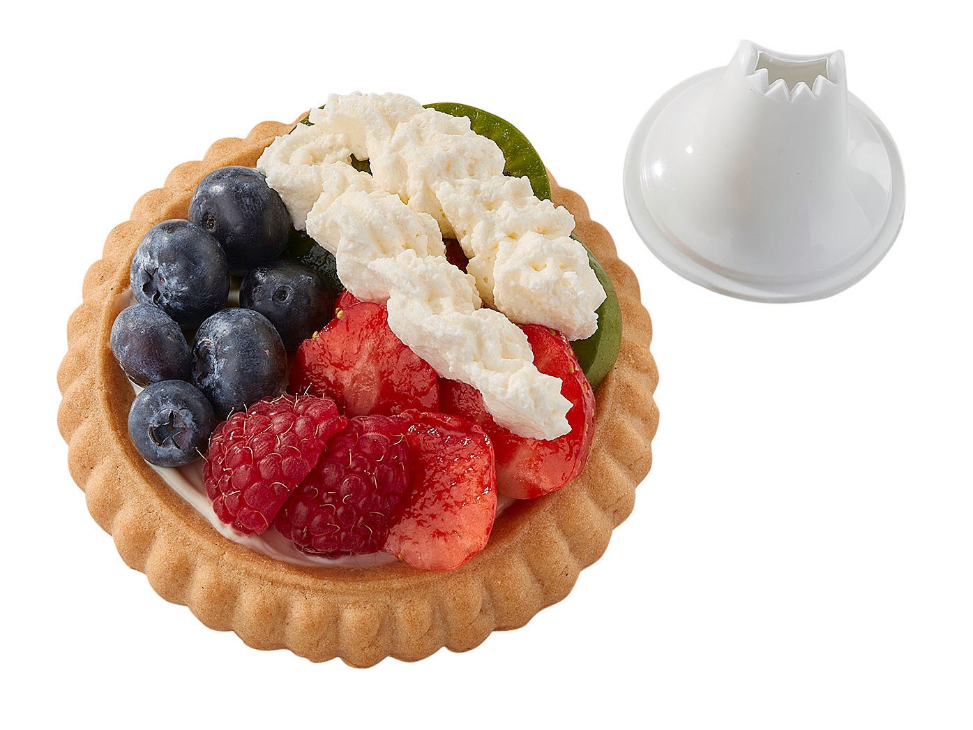 Ein Obsttörtchen mit Himbeeren, Blaubeeren und Sahne wird mit einer Einhand-Garnierspritze dekoriert. Die Spritze liegt neben dem Törtchen und zeigt ihre gezackte Öffnung.