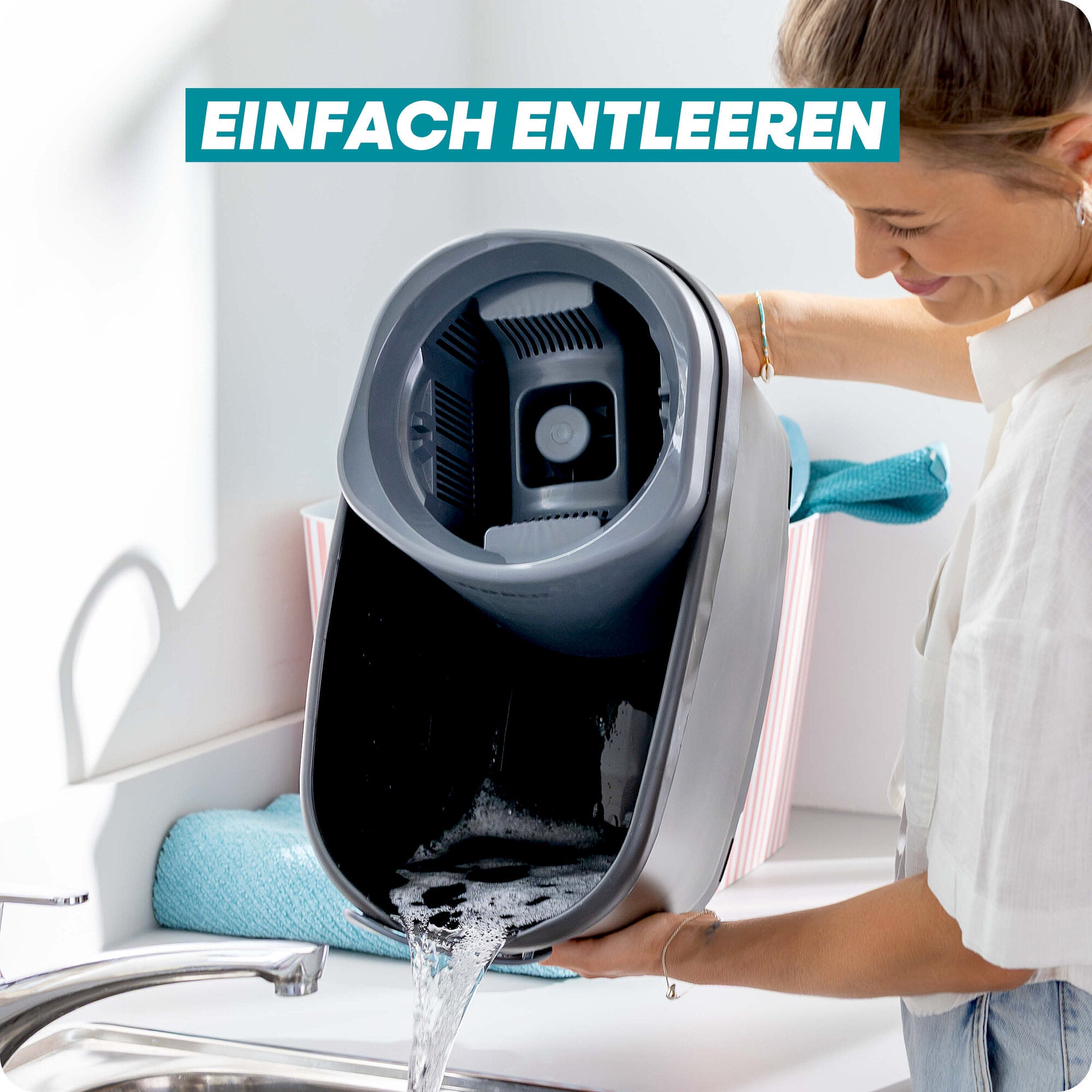 Leifheit Set CLEAN TWIST M Black: Eine Frau entleert den schwarzen Eimer des Bodenwischsystems bequem über dem Spülbecken; Wasser läuft sauber aus, begleitet vom Hinweis „Einfach entleeren“.