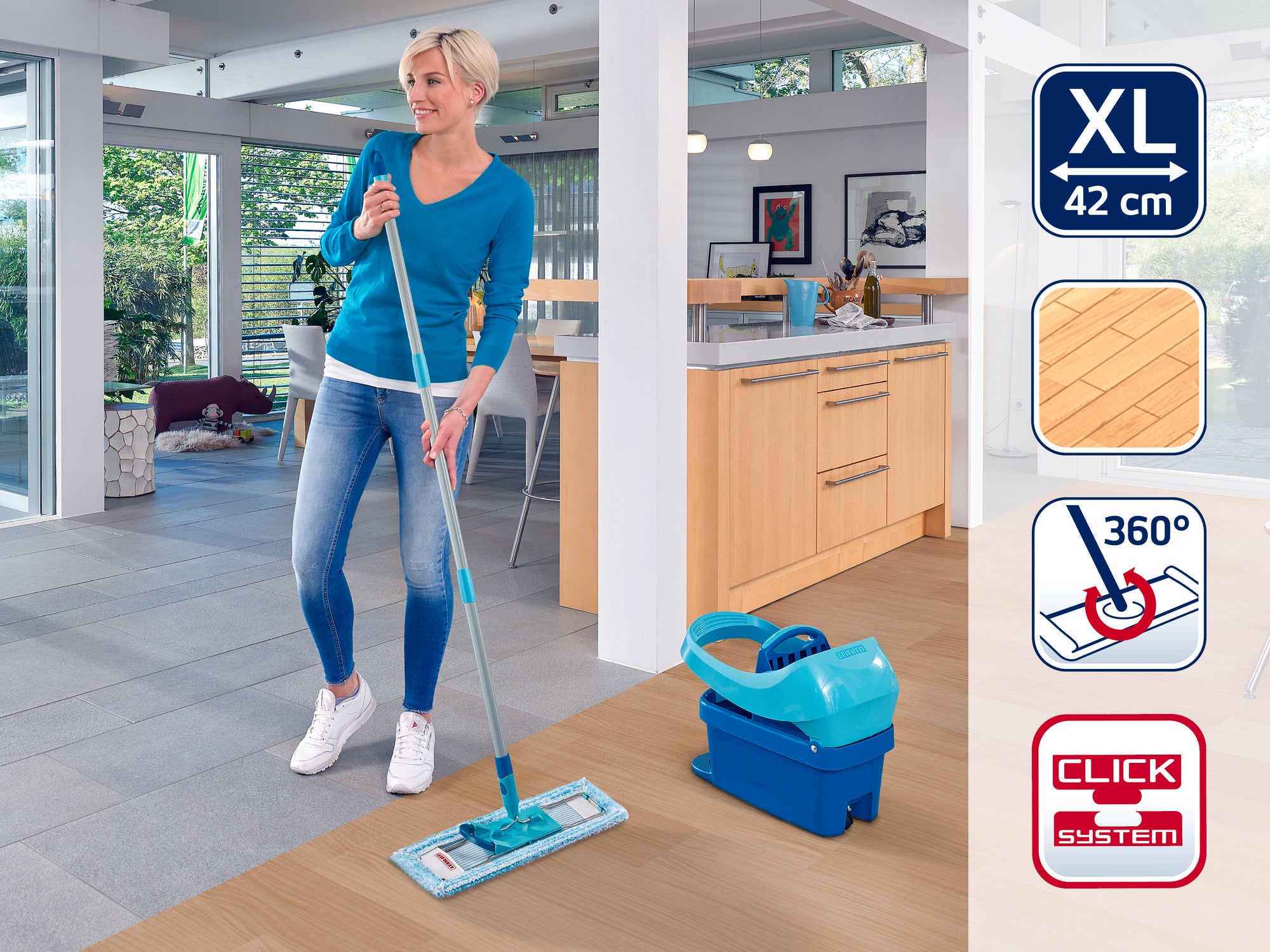 Kobieta myje podłogę w nowoczesnej kuchni mopem Leifheit. Mop ma deskę do wycierania XL o długości 42 cm i przegub obrotowy 360 stopni ułatwiający obsługę.
